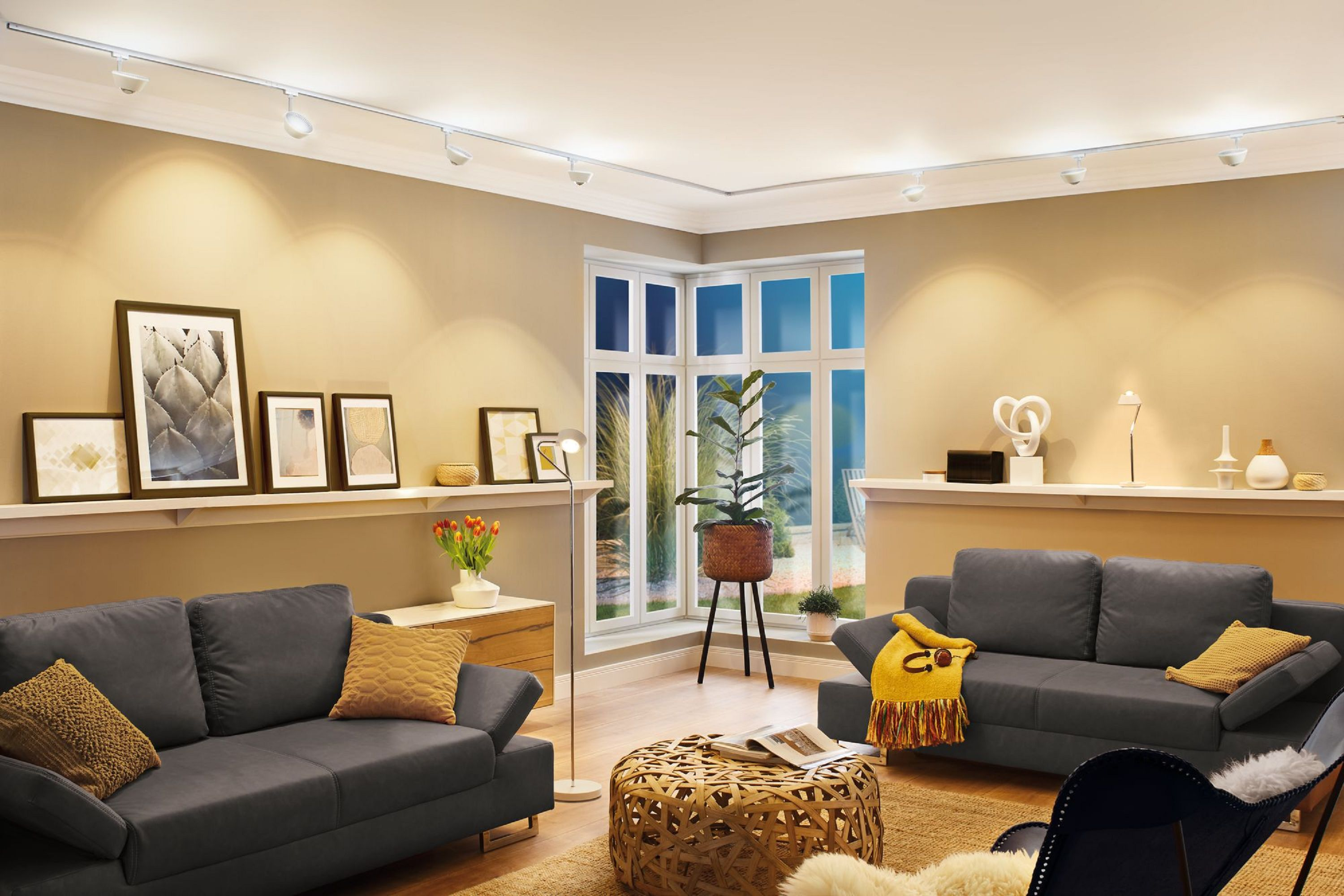 Salon z sofami, stolikiem kawowym i oświetleniem szynowym.