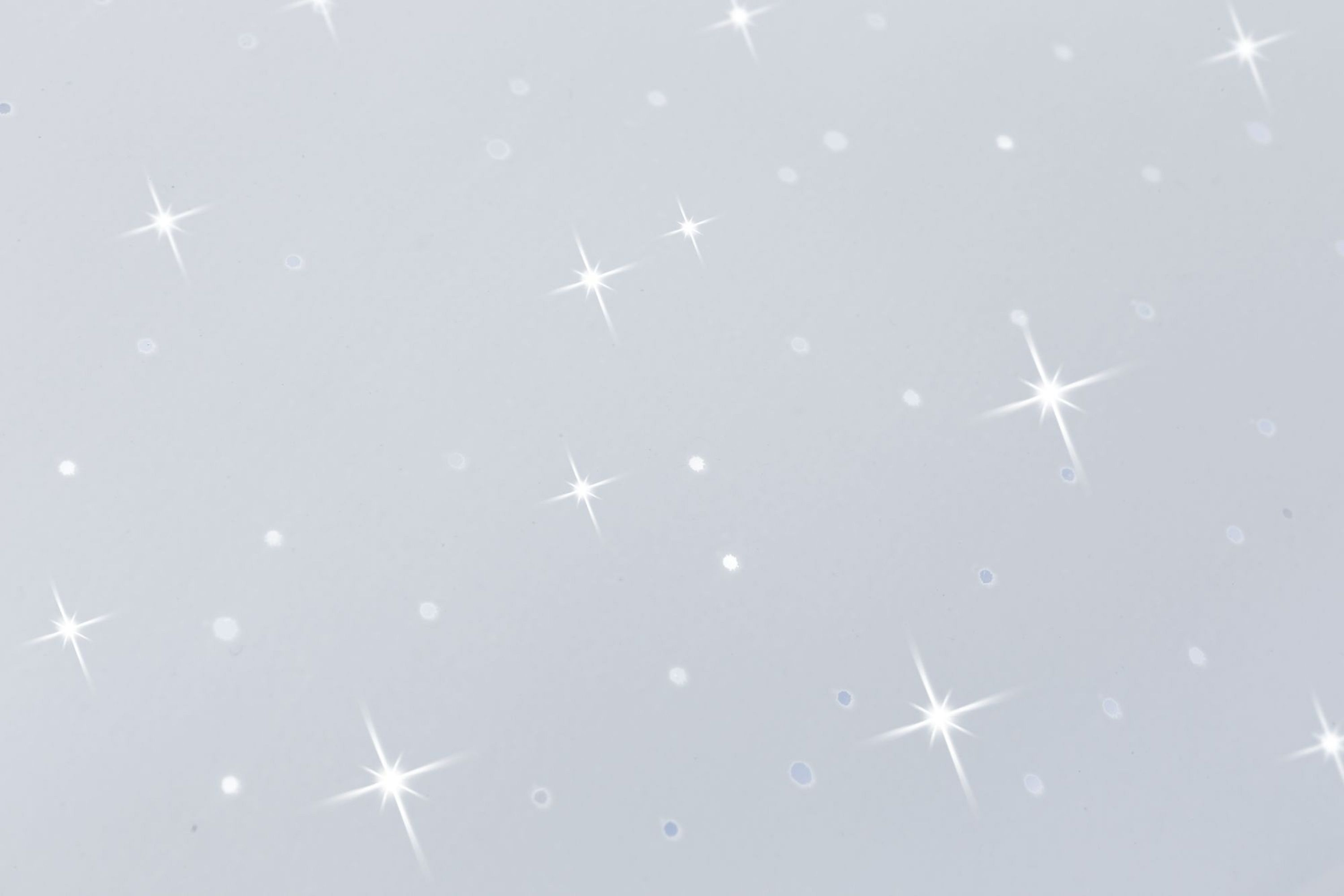 Błyszczące tło z wieloma białymi światłami w kształcie gwiazd.