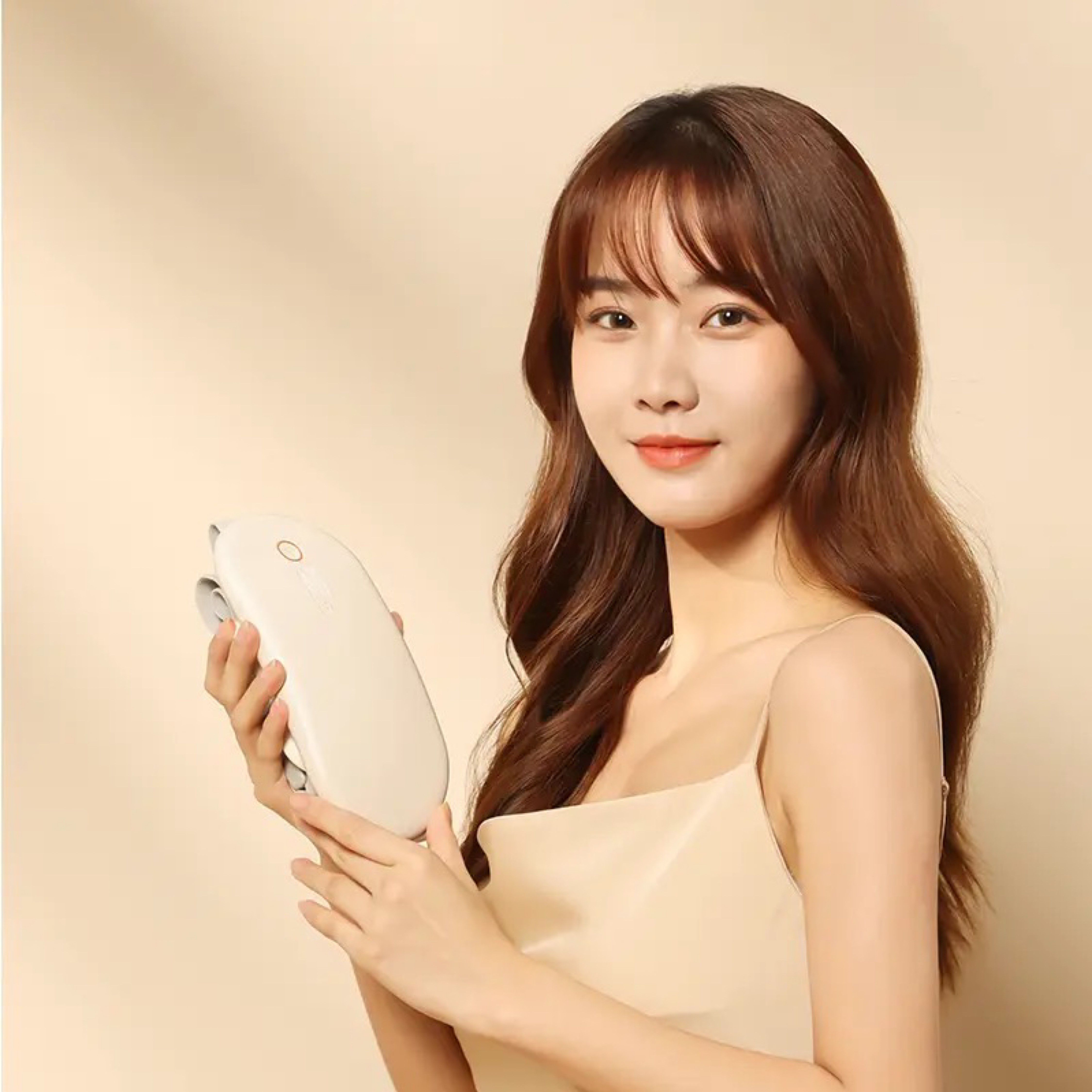 Kobieta trzymająca białe urządzenie. Beżowe tło.
