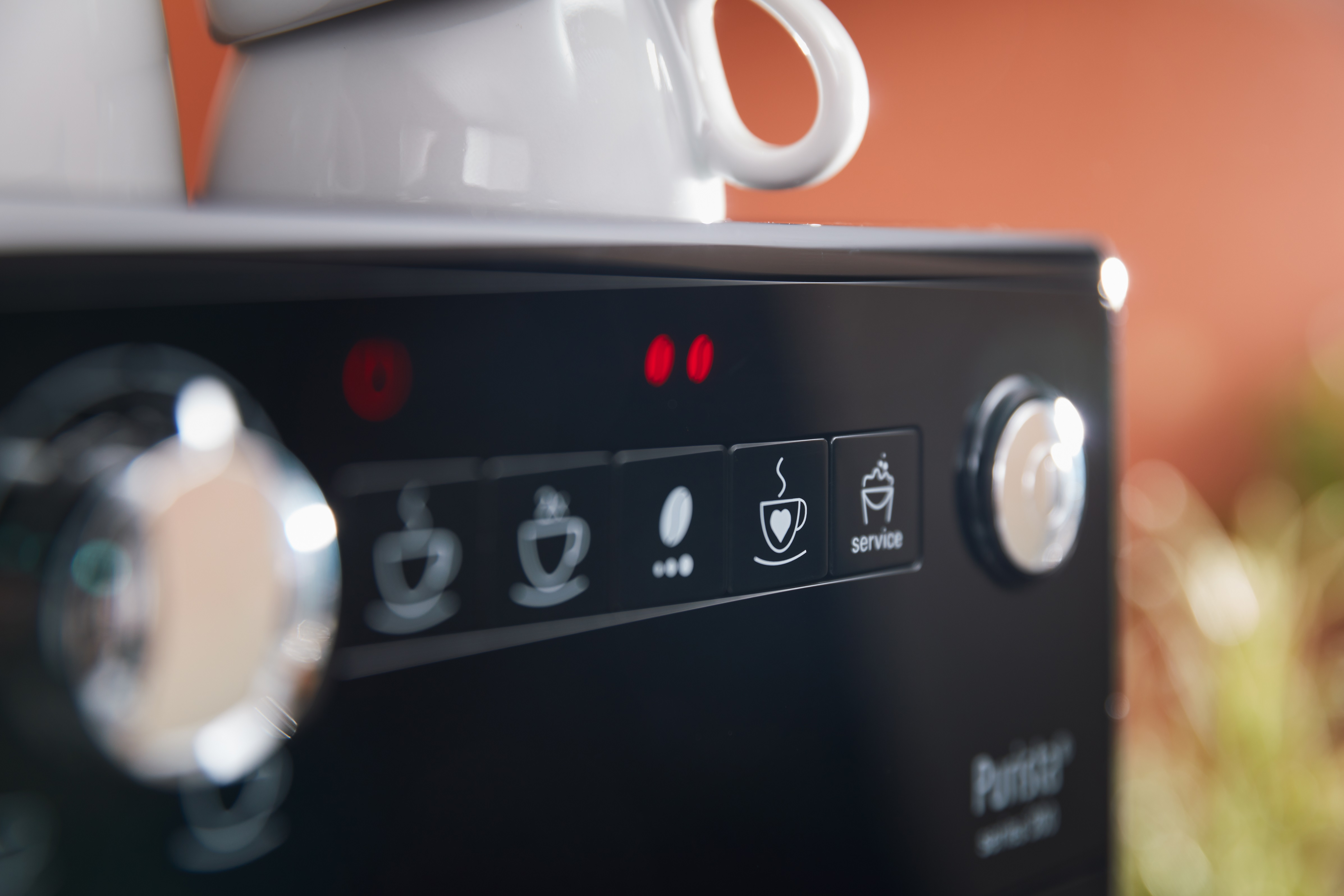 Nahaufnahme einer Kaffeemaschine. Tasten für Kaffeeoptionen und eine Service-Taste sind sichtbar.