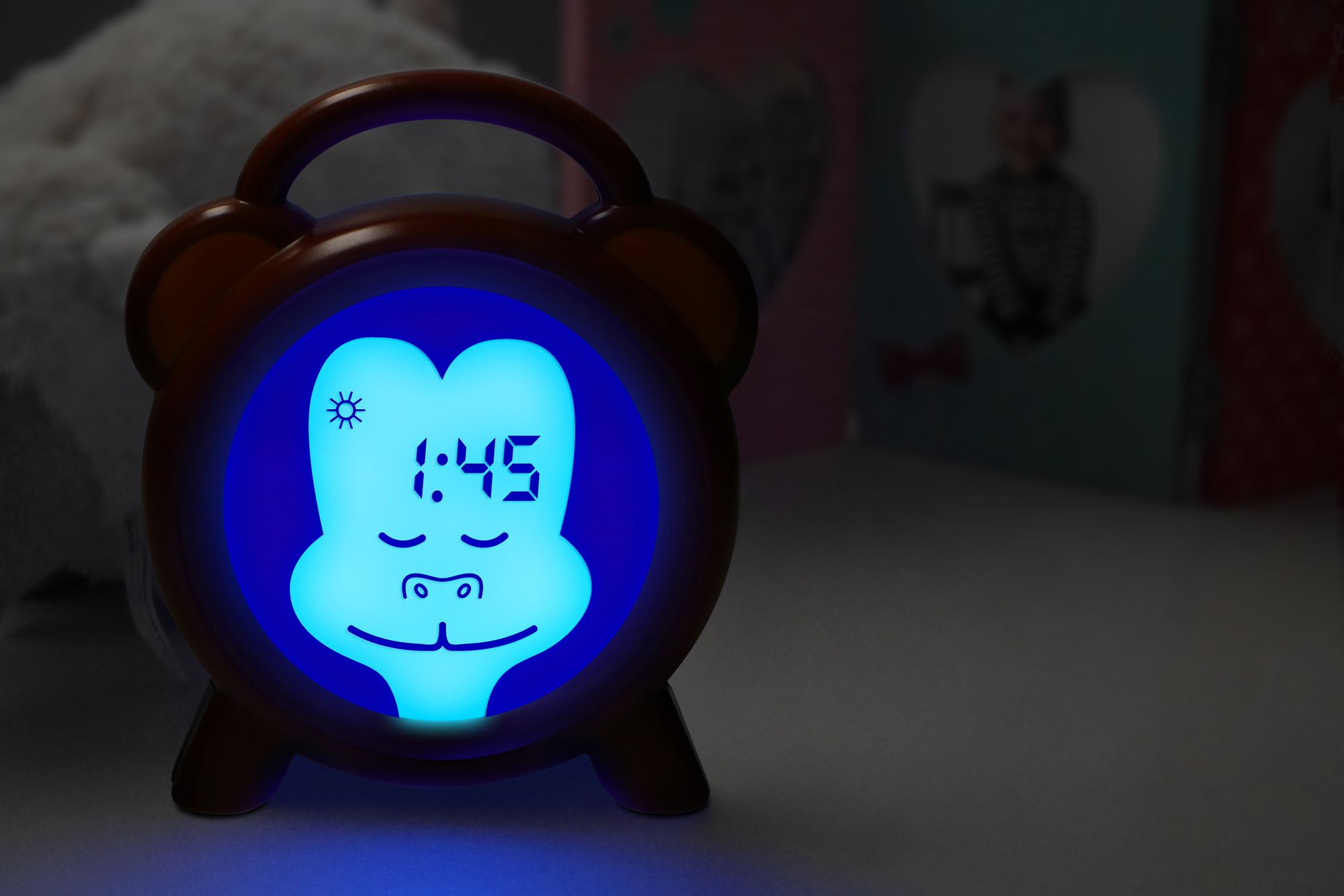 Oranje wekker met blauw licht dat de tijd weergeeft, apengezicht.