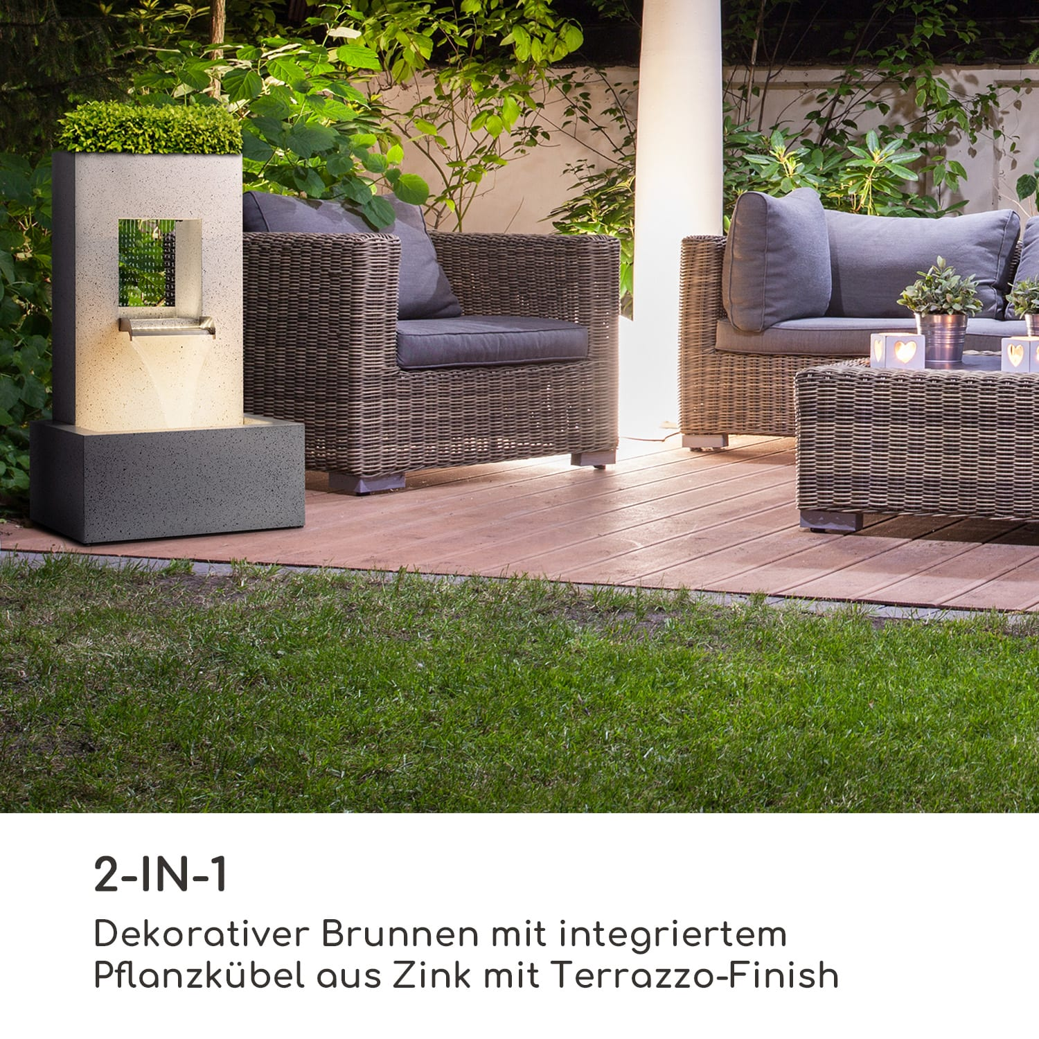 Moderne Außeneinrichtung mit Wasserfontäne, Korbmöbeln und Rasen.