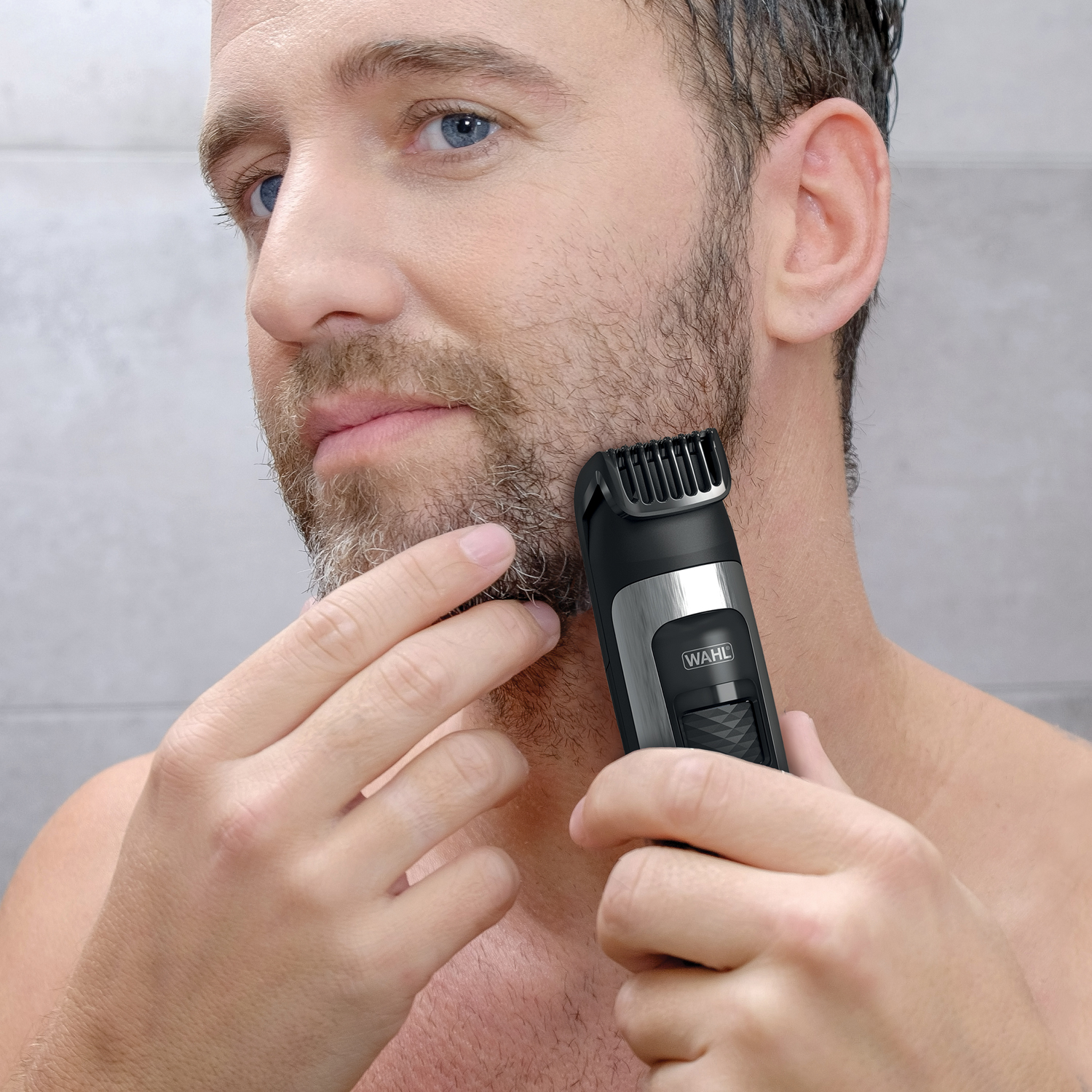 Hombre recortando la barba con recortadora, primer plano.