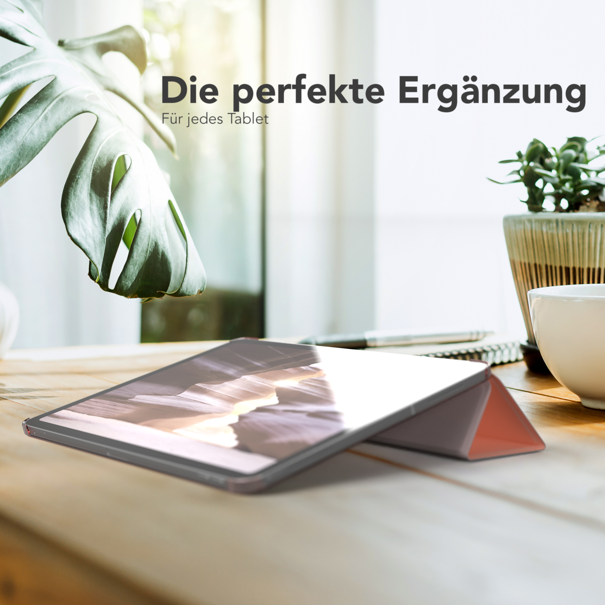 Tablet in einem Gehäuse, platziert auf einem Holztisch mit einer Pflanze und einer Tasse. Hintergrund.