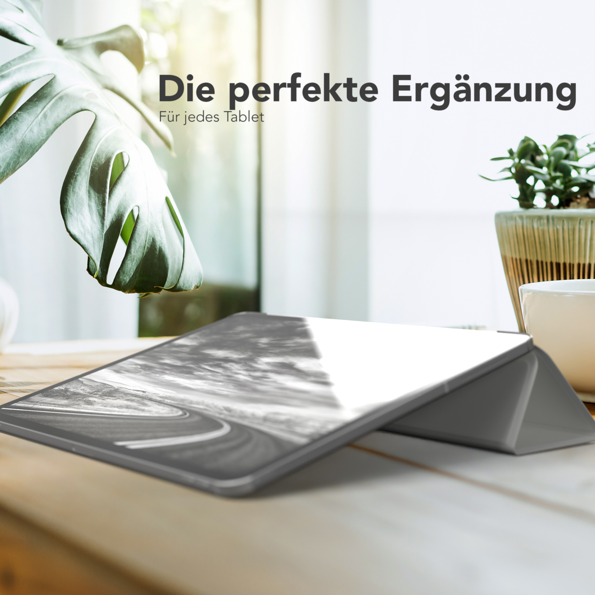 Tablet auf einem Holztisch mit Pflanze, zeigt eine Straßenszene.