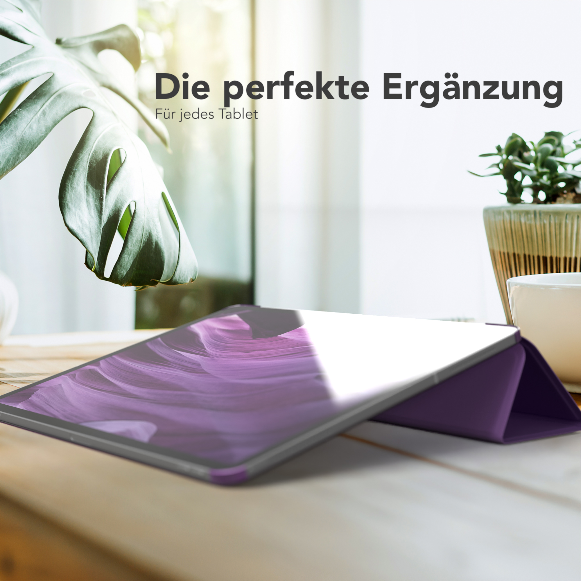 Eine schwarze Hülle mit einem Tablet auf einem Holztisch. Im Hintergrund eine Pflanze.