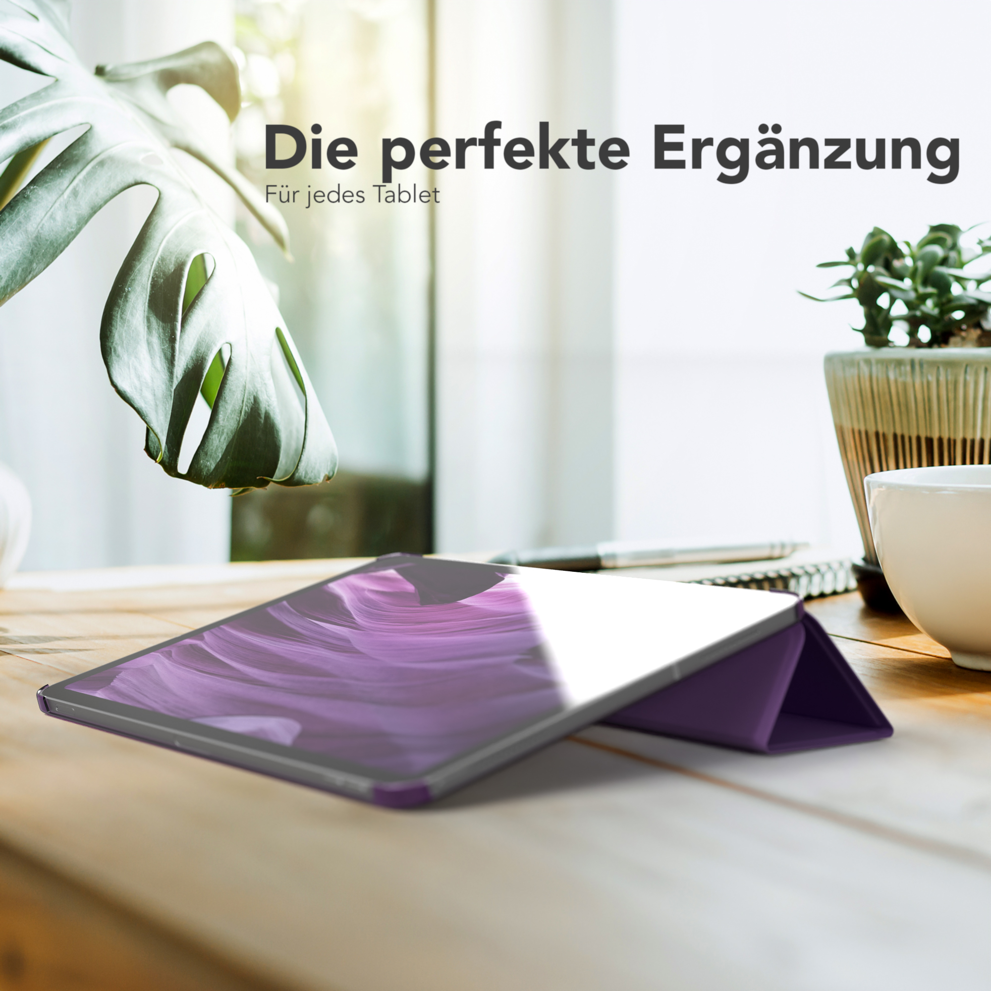 Tablet in lila Hülle auf Holztisch, mit Pflanze und Tasse.