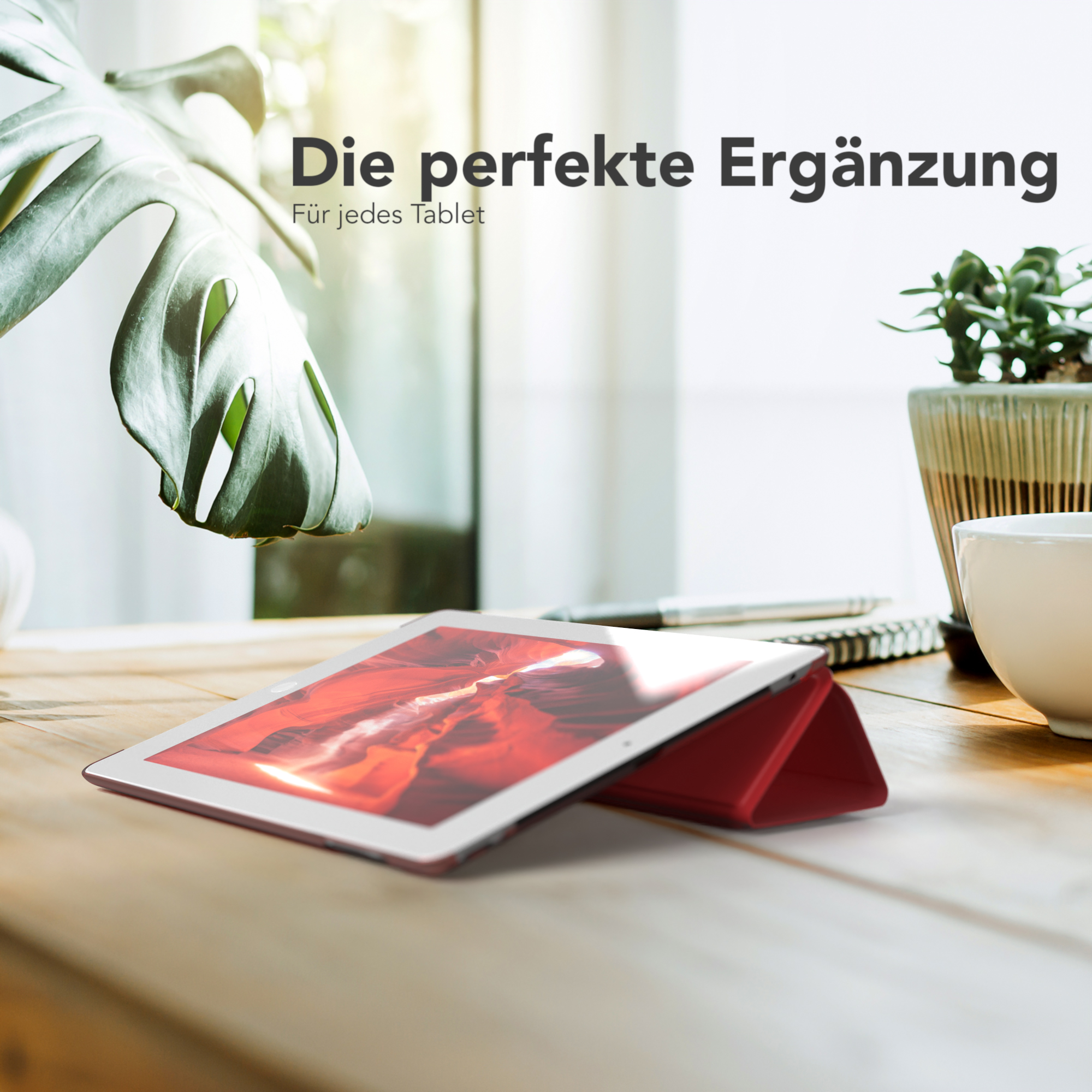 Tablet mit roter Hülle auf Holztisch, mit Pflanze. Text sagt 'Die perfekte Ergänzung'.