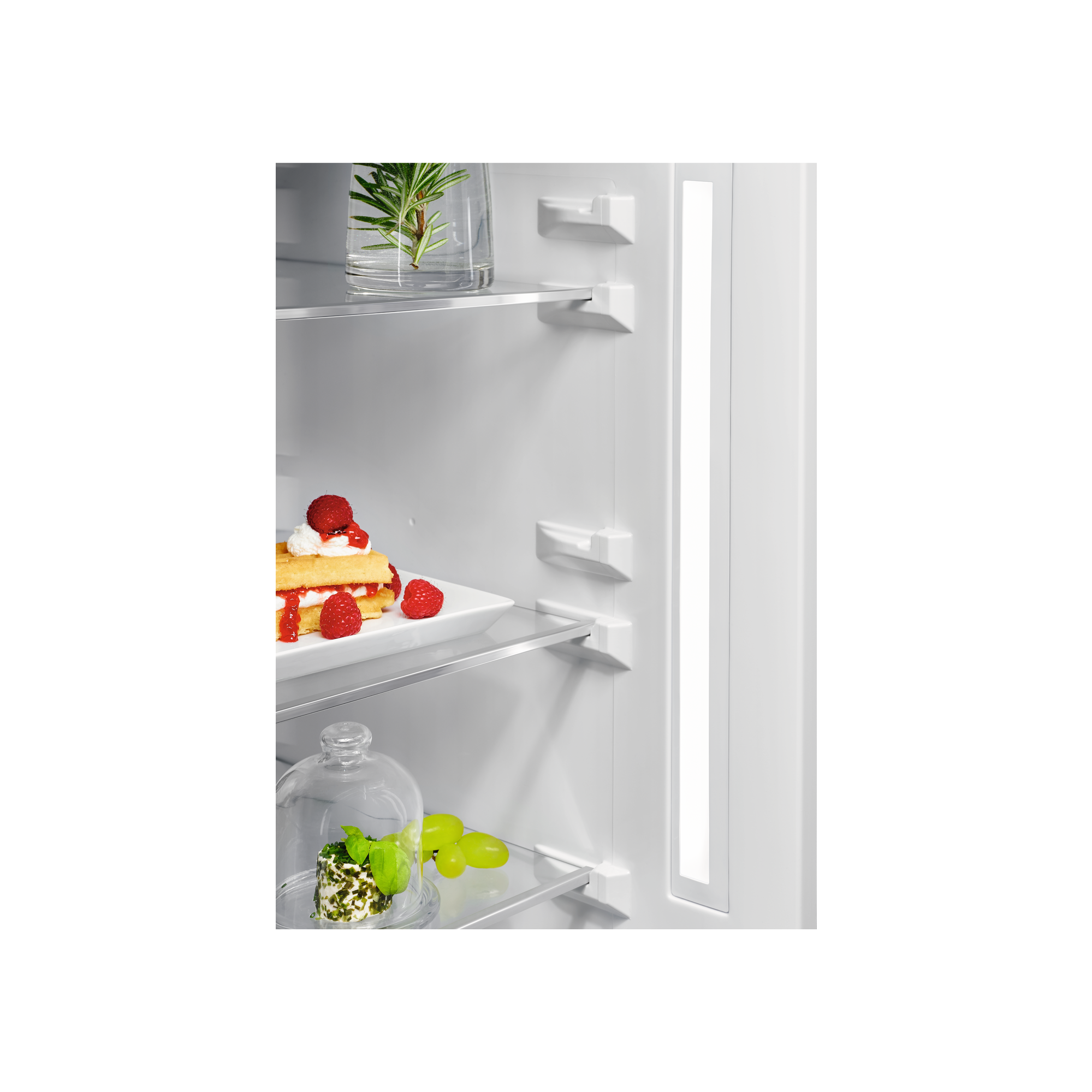 Wnętrze lodówki z półkami i ciastem z owocami.