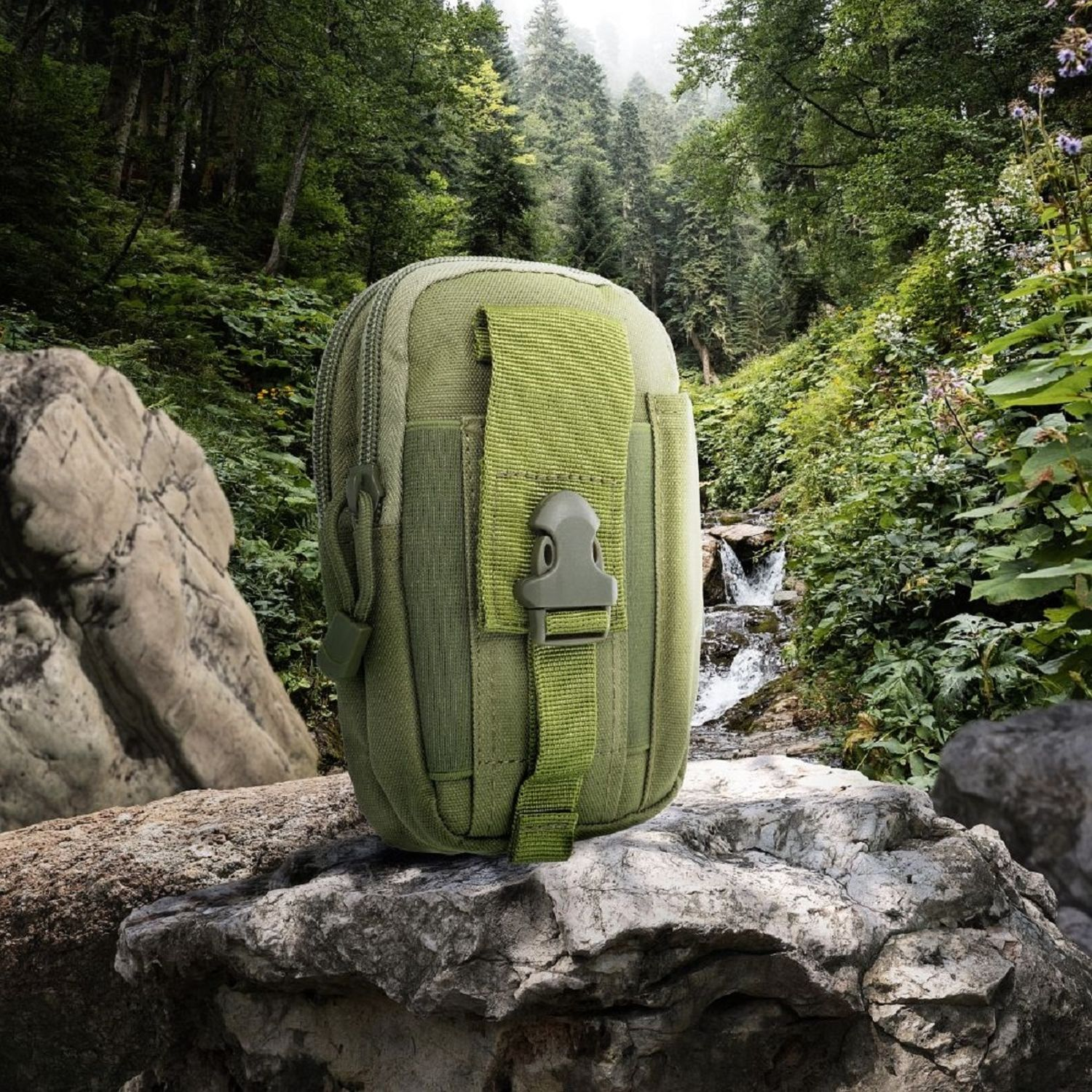 Grüner taktischer Beutel auf einem Felsen. Im Hintergrund ein Wasserfall und ein Wald mit grünen Bäumen.