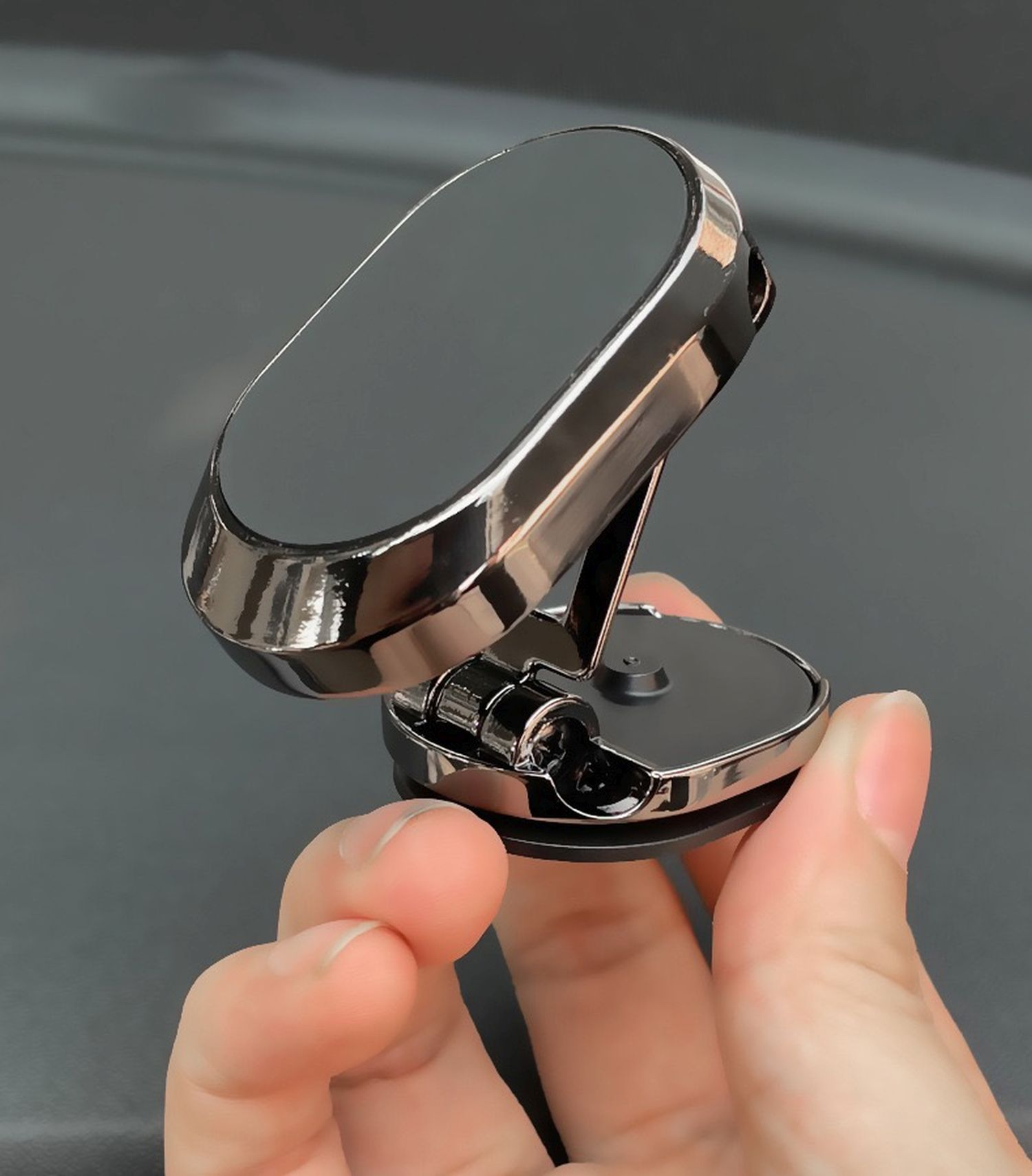 Ein silberner Autotelefonhalter in der Hand einer Person. Er ist abgewinkelt und hat eine magnetische Oberfläche.