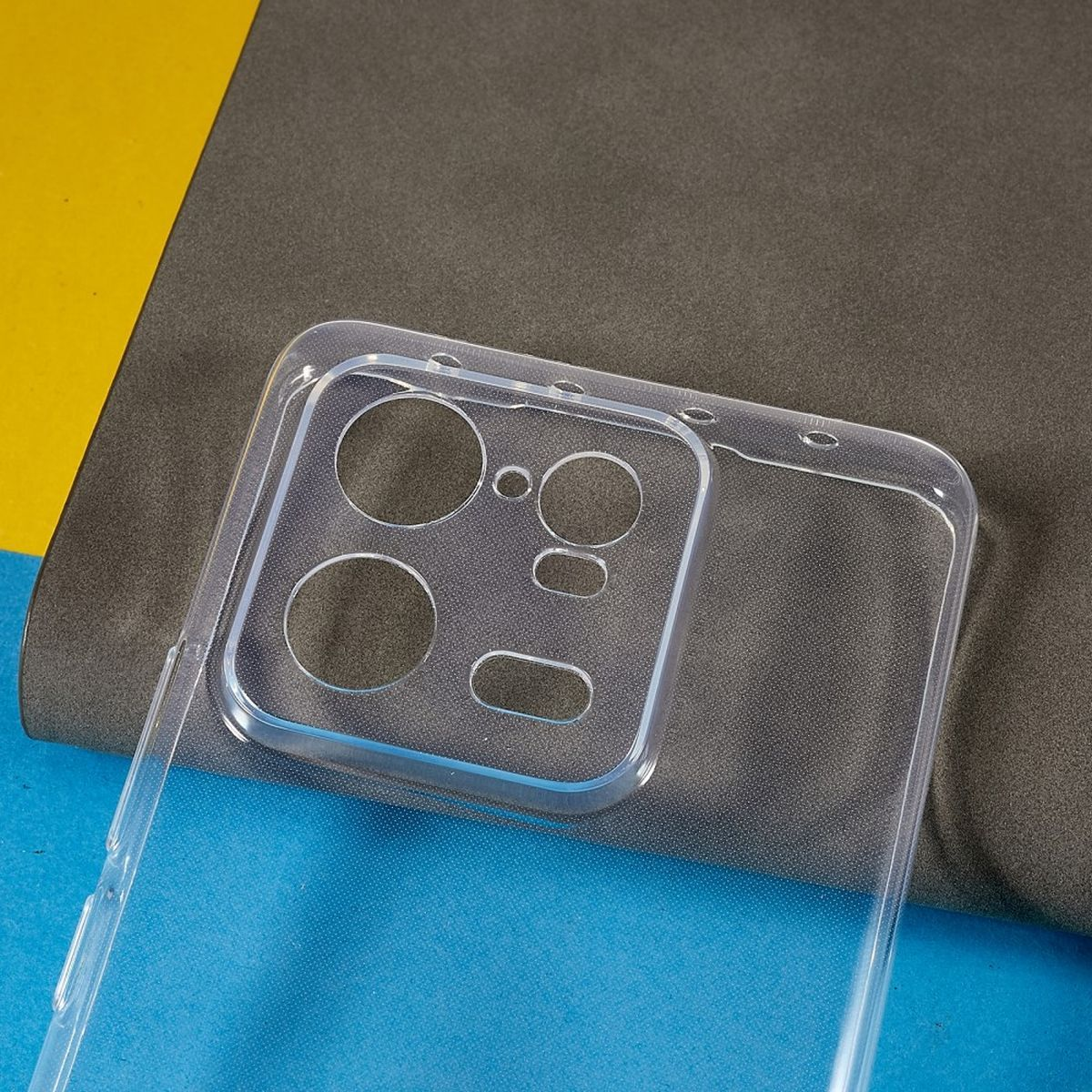Transparente Handyhülle auf blau-gelbem Hintergrund. Die Hülle hat Aussparungen für Kamera und andere Komponenten.