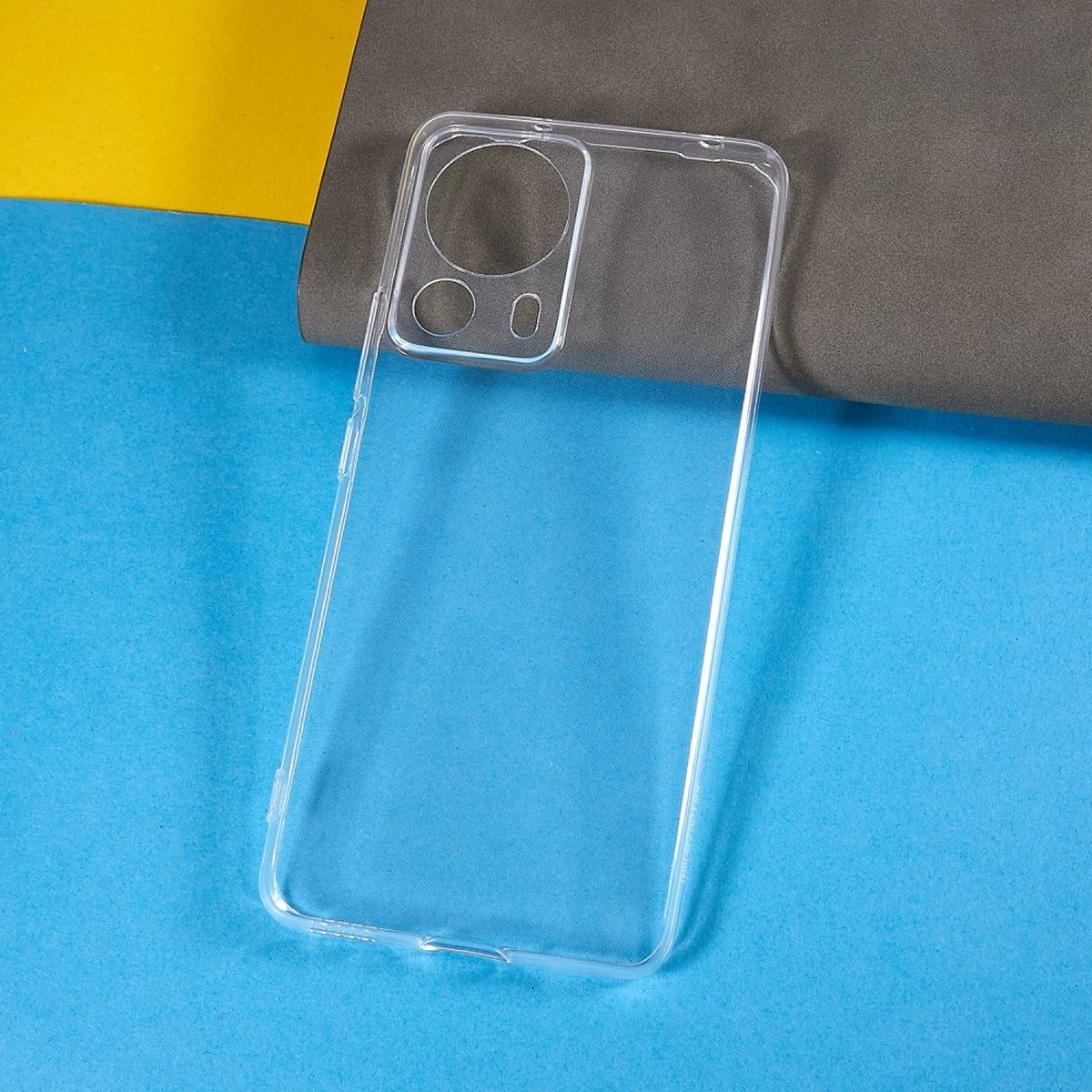 Transparente Handyhülle, auf blauem und grauem Hintergrund. Kreisförmige Kameraausschnitte sichtbar.
