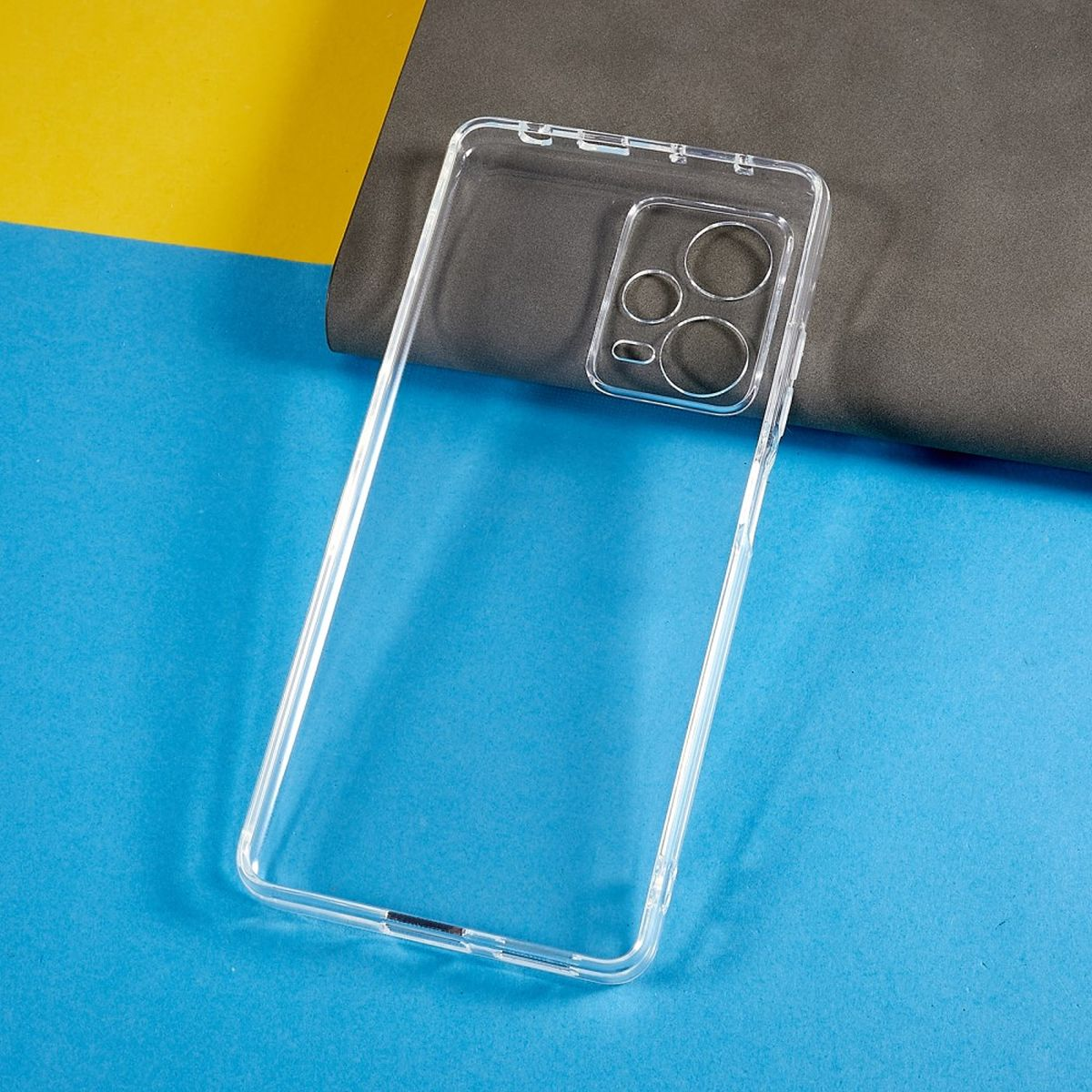 Klare Handyhülle. Sie ist transparent, mit Kameraausschnitten, auf blau-gelbem Hintergrund.