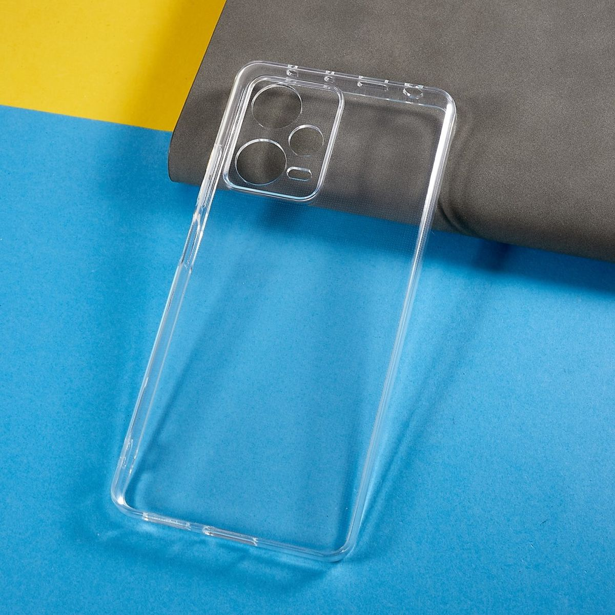 Klare Handyhülle. Sie ist transparent, mit Kameraausschnitten. Blauer, gelber und grauer Hintergrund.