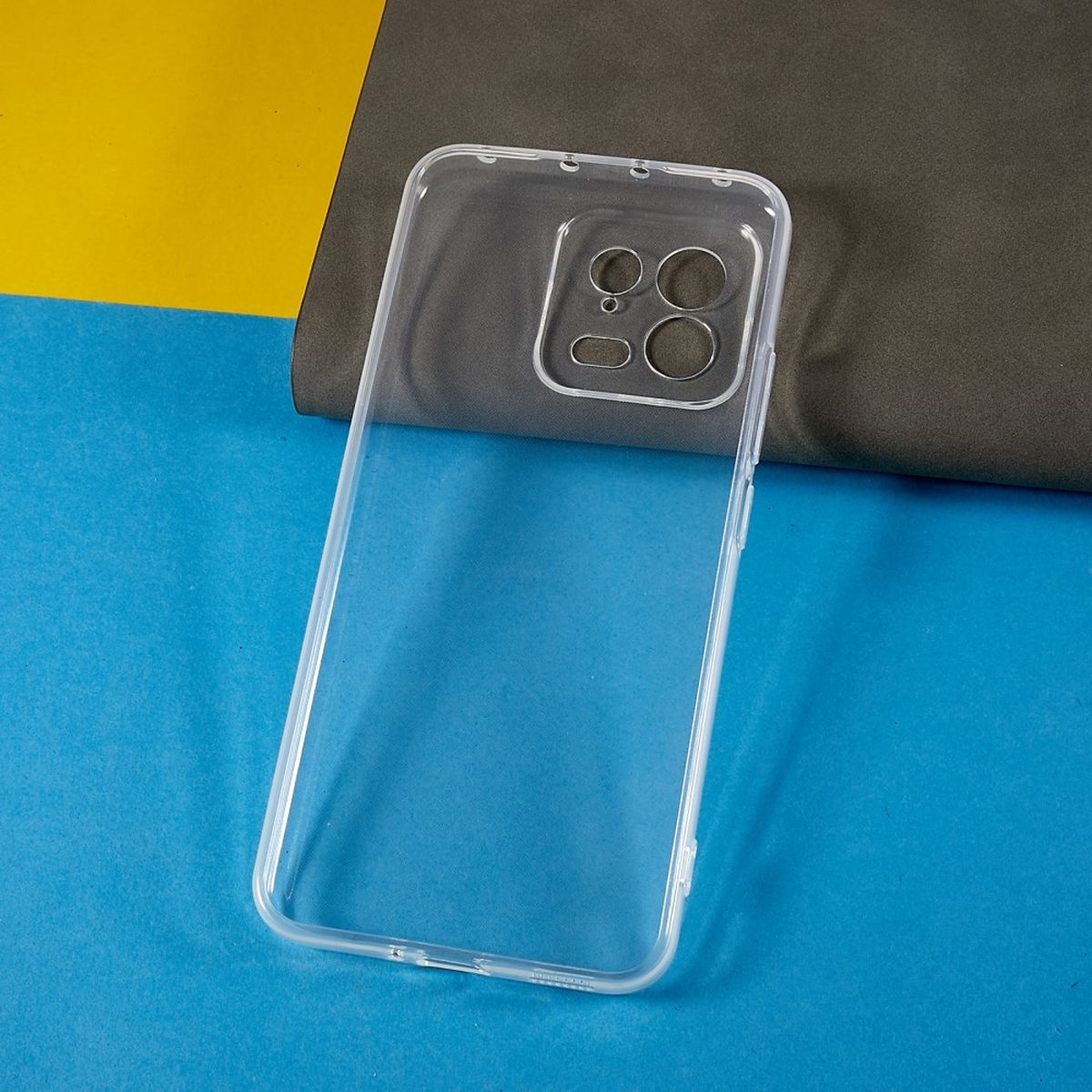 Eine transparente Handyhülle auf blauen und gelben Oberflächen.
