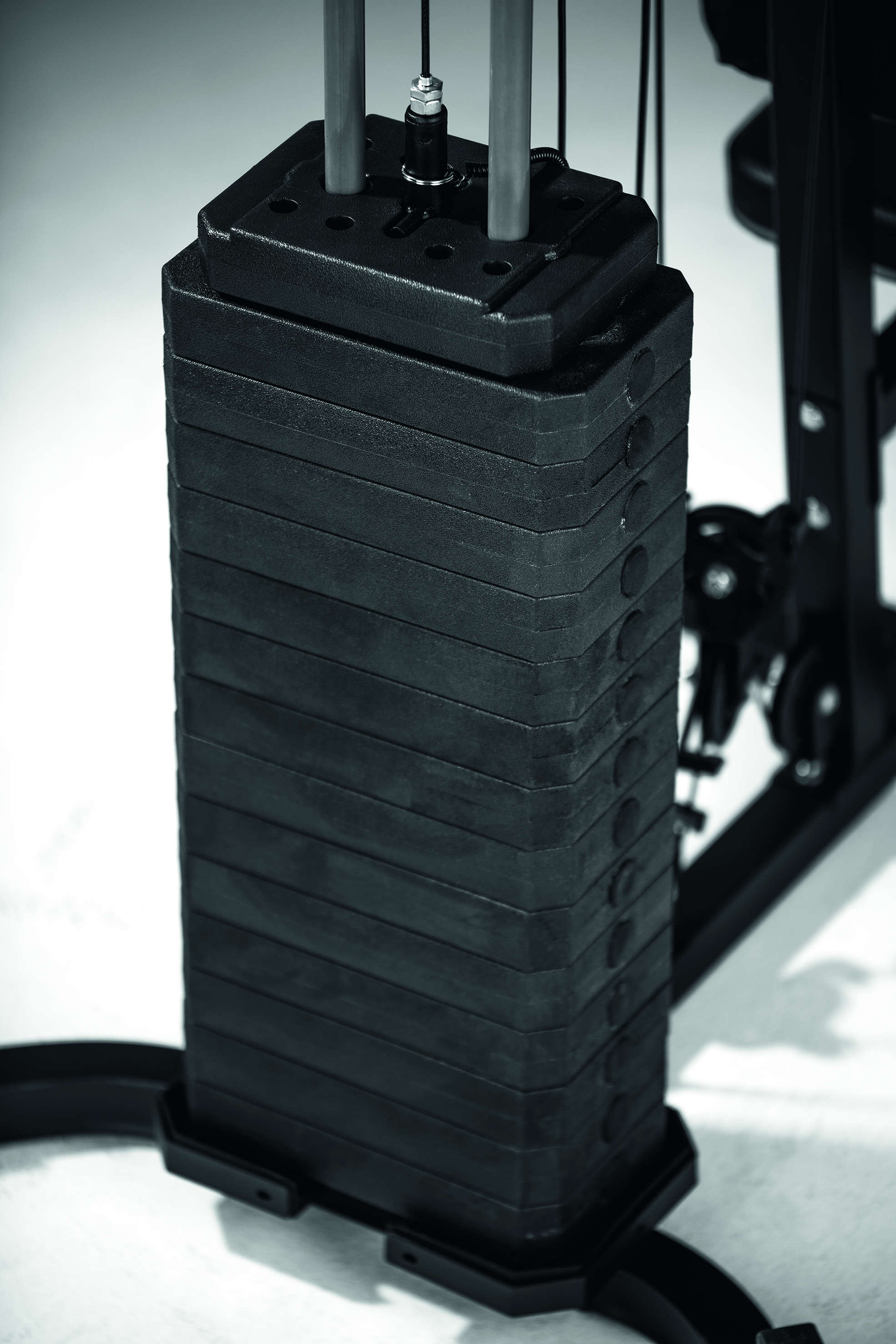 Ein Stapel schwarzer Gewichte an einer Fitnessmaschine. Monochromes Bild, schwarz und weiß.