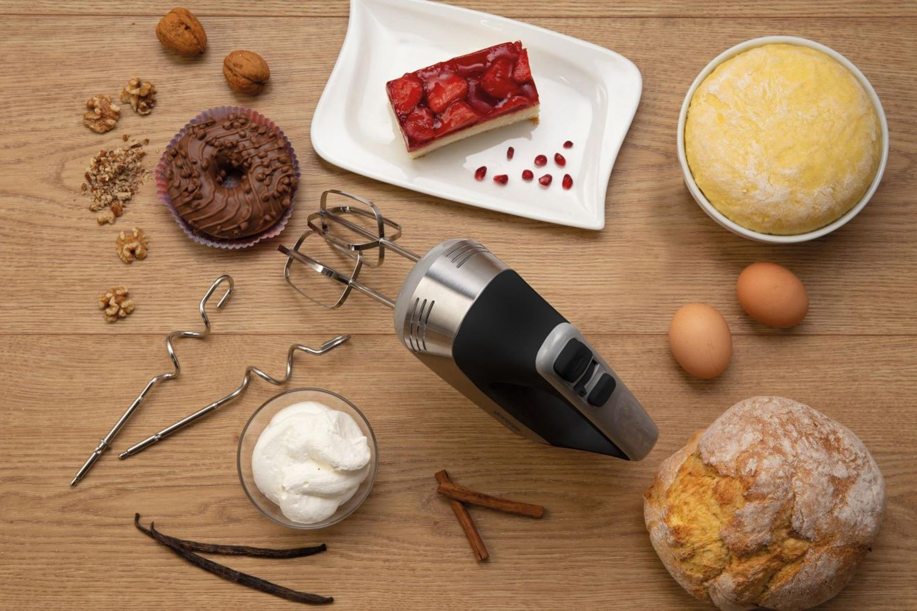Draufsicht auf Backzutaten: Teig, Eier, Nüsse, Donut, Kuchen und ein Mixer.