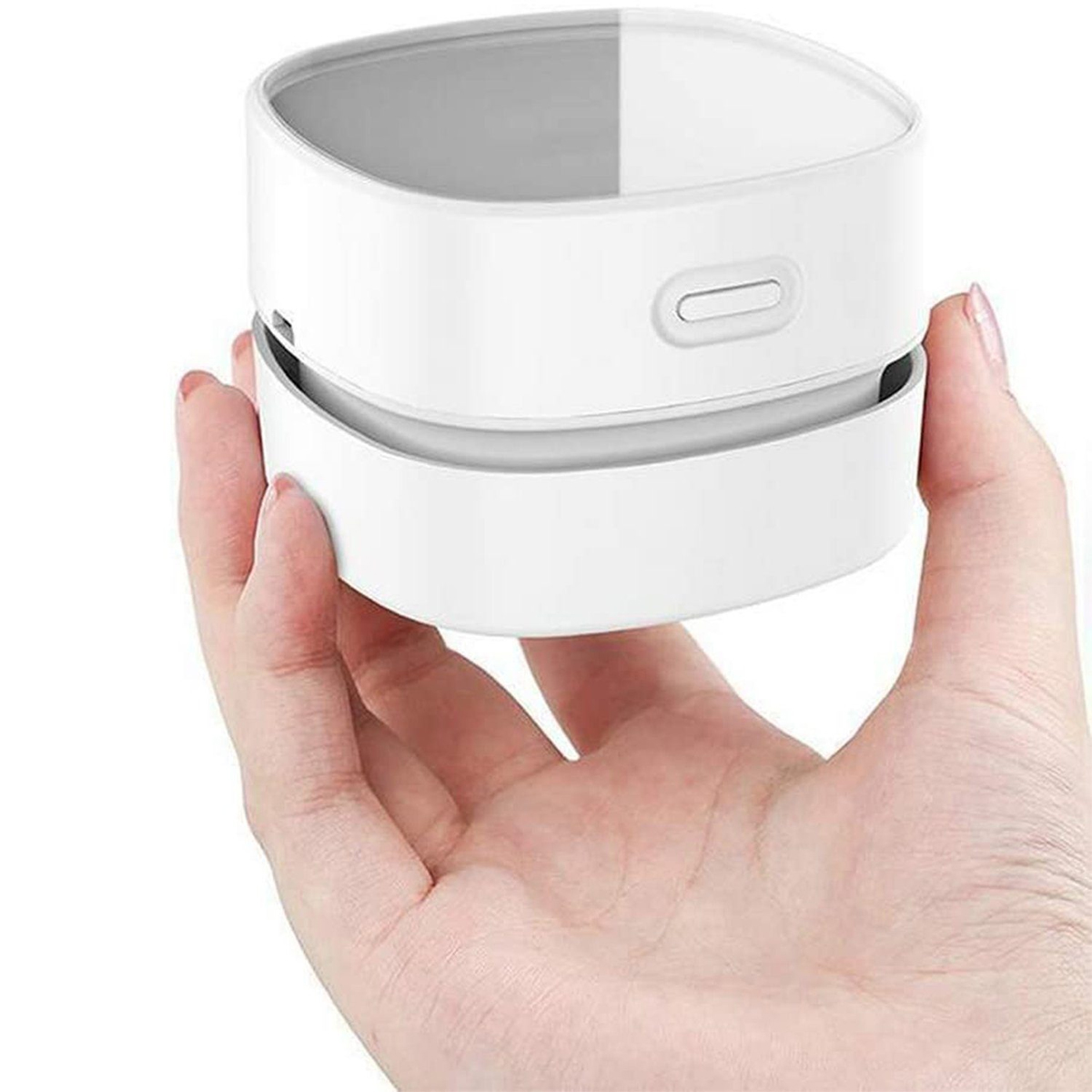 Biały, cylindryczny mini odkurzacz trzymany w dłoni.