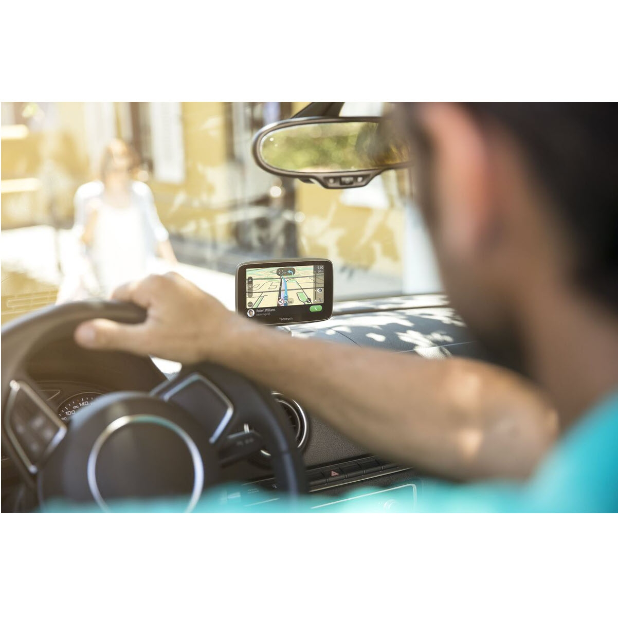 Eine Person benutzt ein GPS im Auto, das eine Karte und die Straße zeigt.