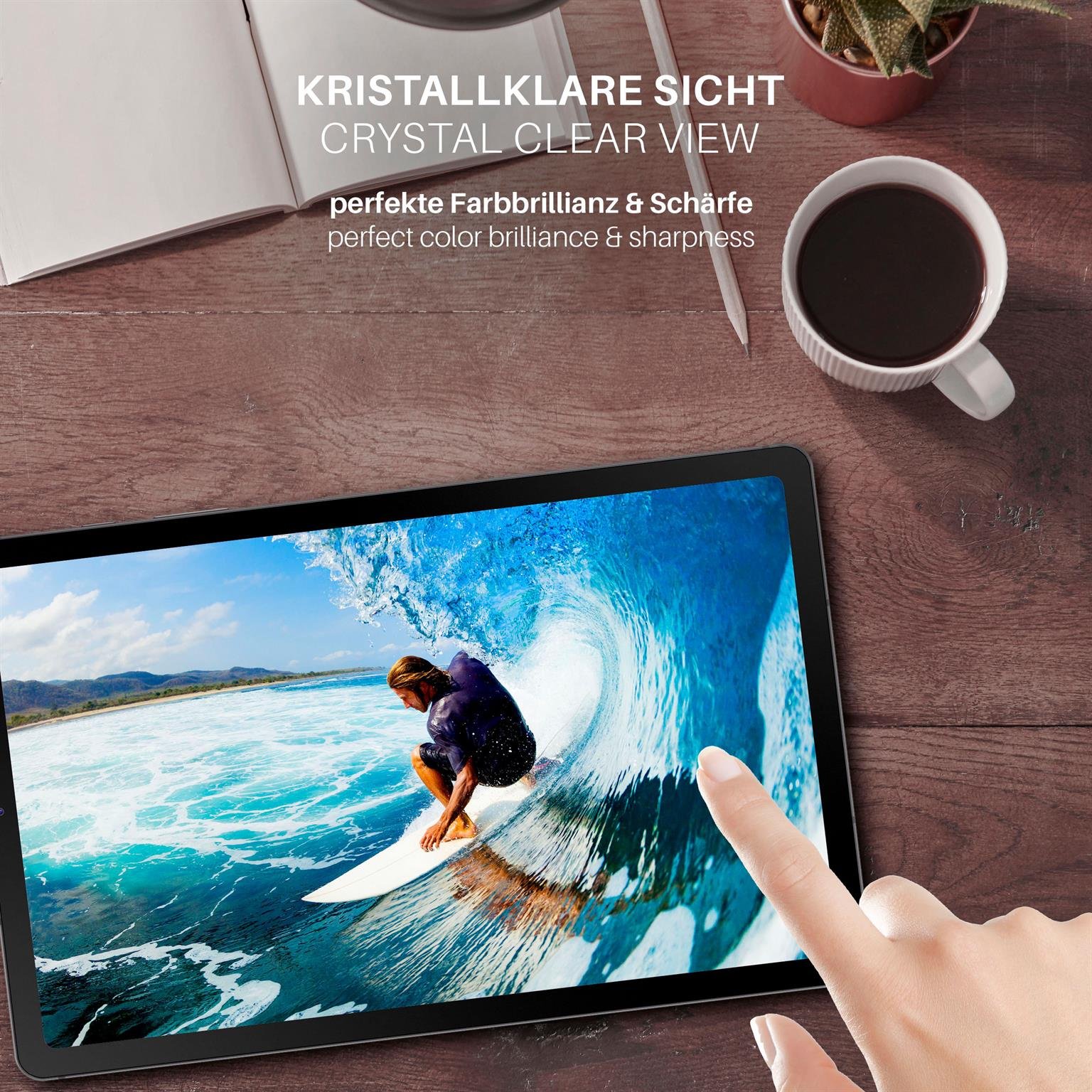 Ein Tablet zeigt einen Surfer auf einer Welle. Eine Hand berührt den Bildschirm. Andere Gegenstände auf einem Holztisch.