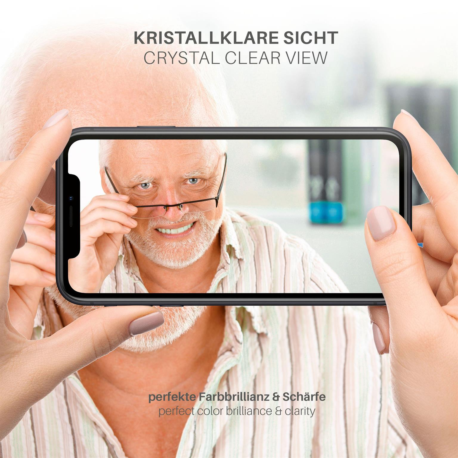 Hände, die ein Telefon halten, das einen älteren Mann mit Brille zeigt. Text: Kristallklare Sicht, perfekte Farbbrillanz & Schärfe.