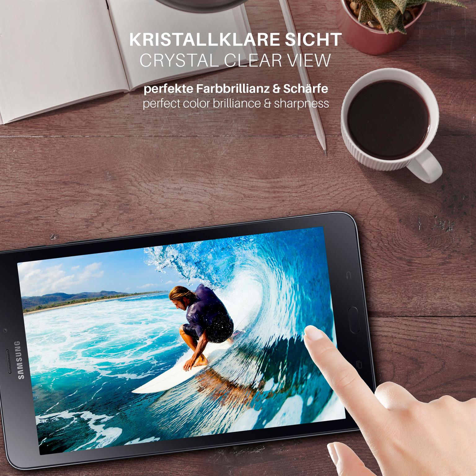 Ein Finger berührt einen Tablet-Bildschirm, der einen Surfer auf einer Welle zeigt. Kaffee und ein Stift sind in der Nähe.