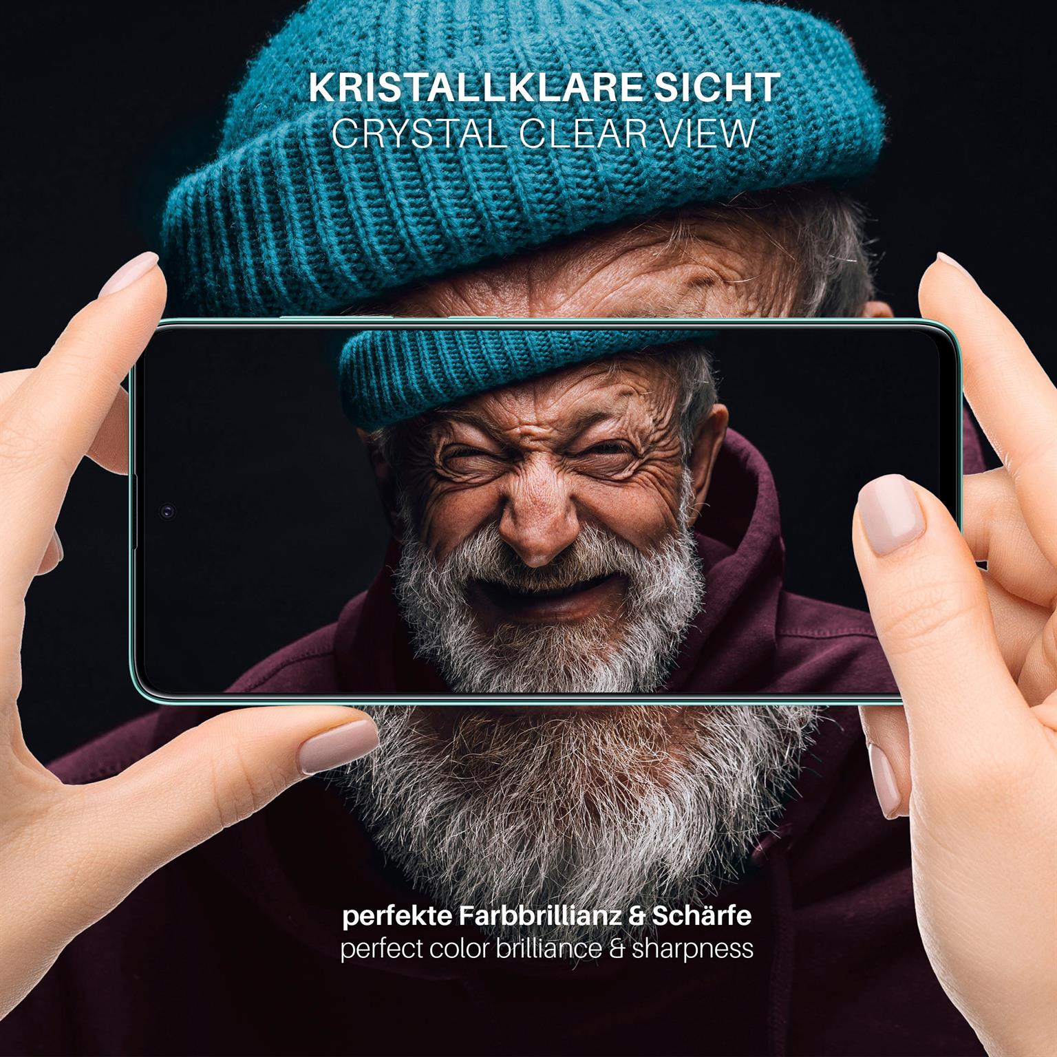 Hände halten ein Telefon, das einen älteren Mann zeigt, der lächelt. Er trägt einen blauen Hut und rote Jacke.