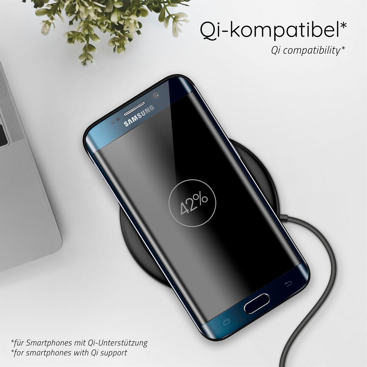 Ein Samsung-Telefon, das auf einem kabellosen Pad geladen wird. Ein Laptop befindet sich im Hintergrund.