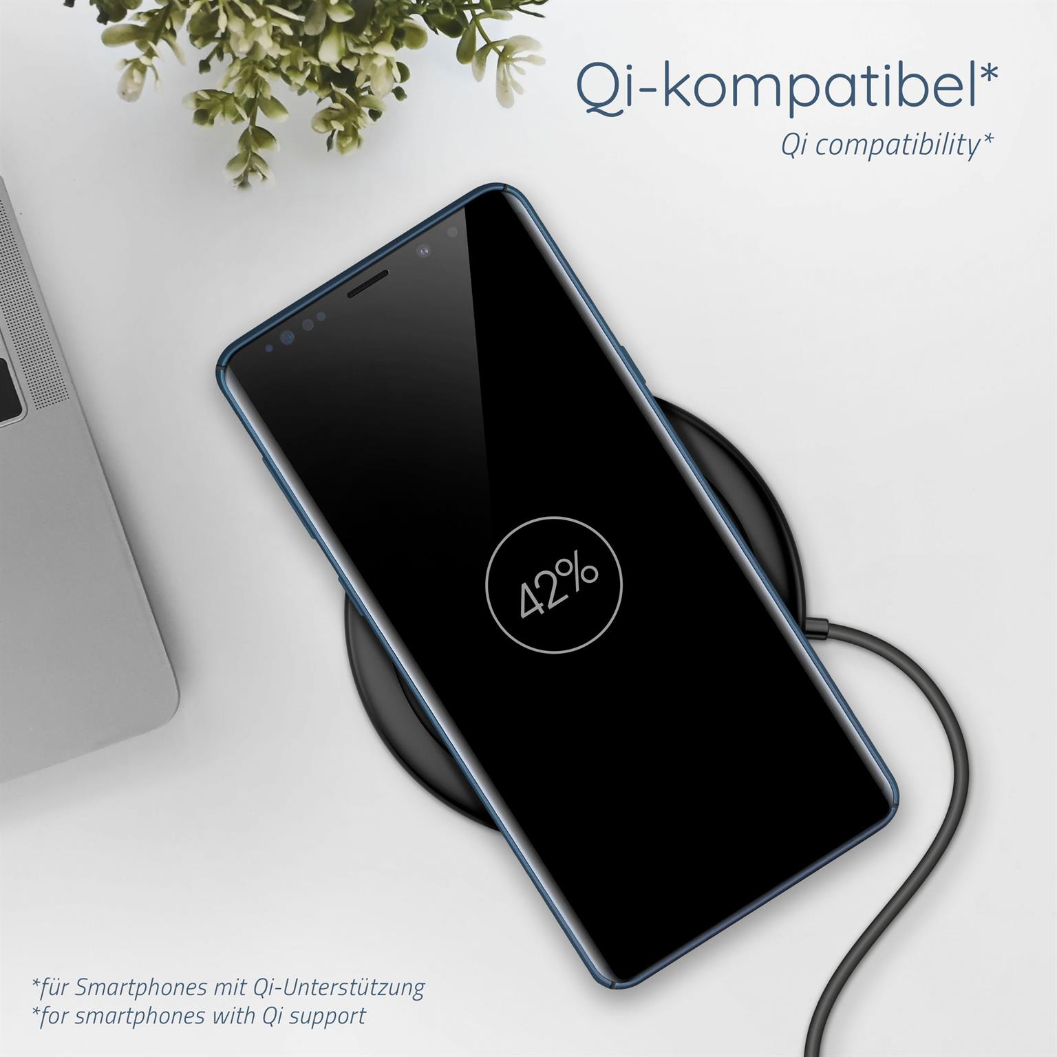 Ein Telefon lädt drahtlos auf einem schwarzen Pad. Der Telefonbildschirm ist schwarz und zeigt 42%.