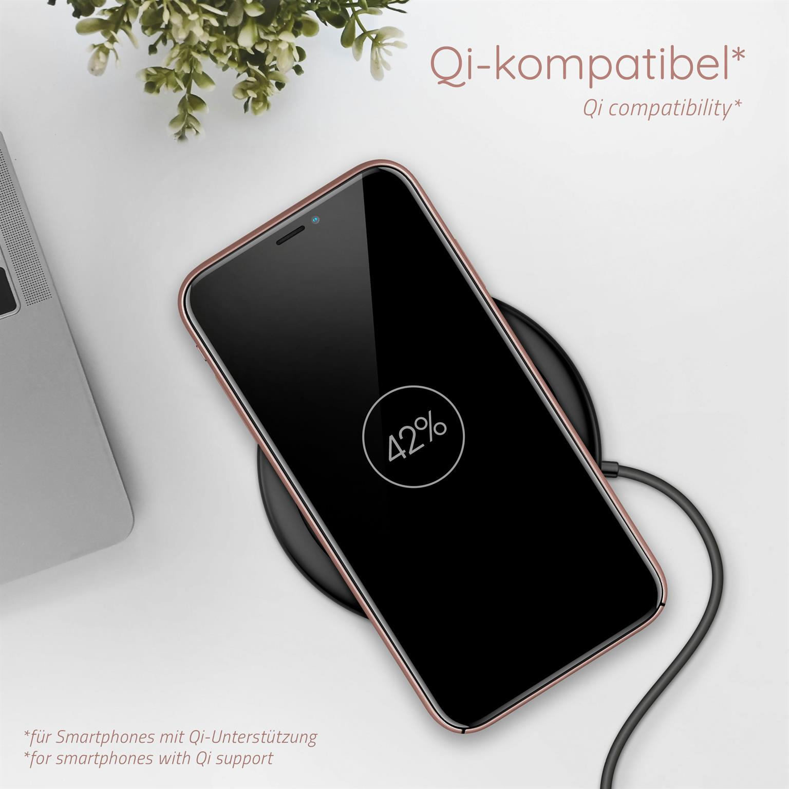 Telefon lädt kabellos. Der Bildschirm zeigt 42% Akku. Eine kleine Pflanze im Hintergrund.