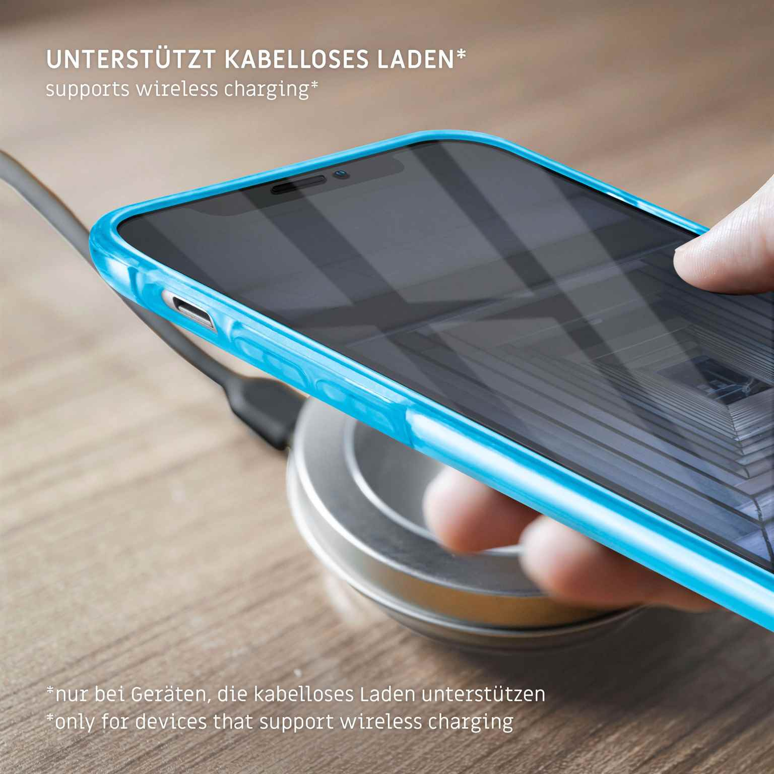 Ein Telefon in einer blauen Hülle, das drahtlos auf einem silbernen Ladepad geladen wird.