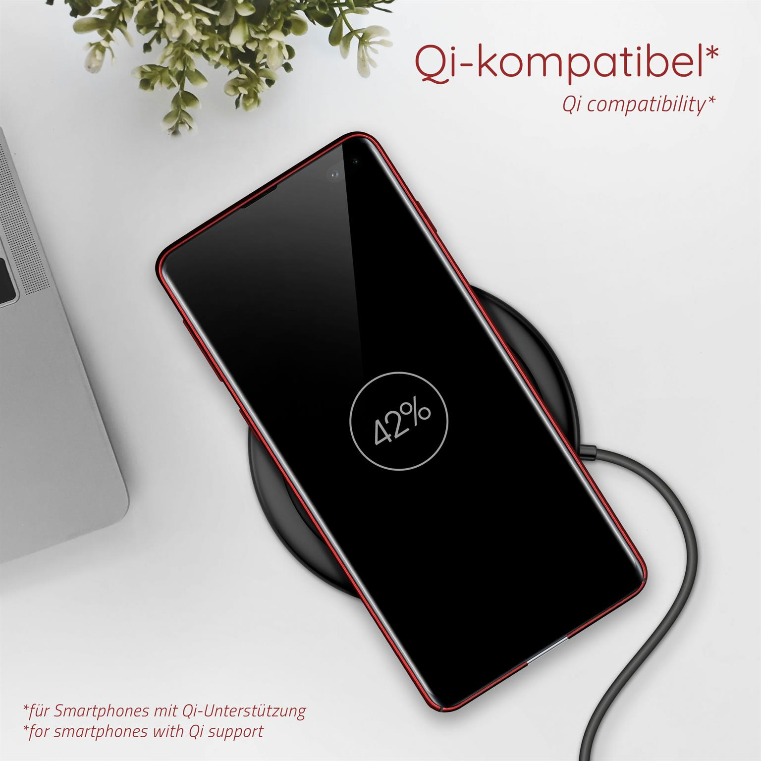 Ein Smartphone auf einem kabellosen Ladegerät, zeigt 42% Akku, mit rotem Rahmen und einer Pflanze im Hintergrund.