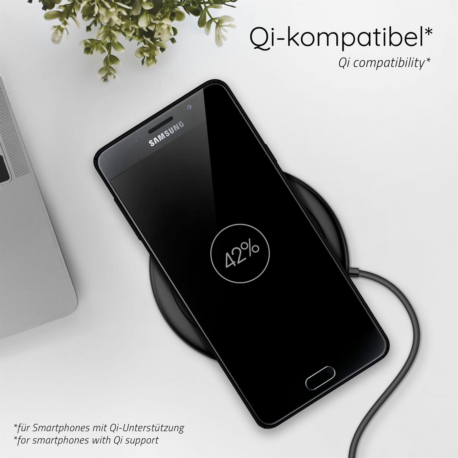 Ein schwarzes Telefon auf einem kabellosen Ladegerät, das 42% Akku anzeigt. Im Hintergrund eine Pflanze.