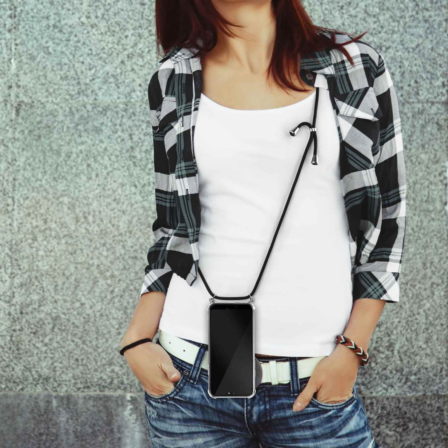 Eine Frau in einem karierten Hemd und weißem Tanktop trägt ein Handy-Lanyard.
