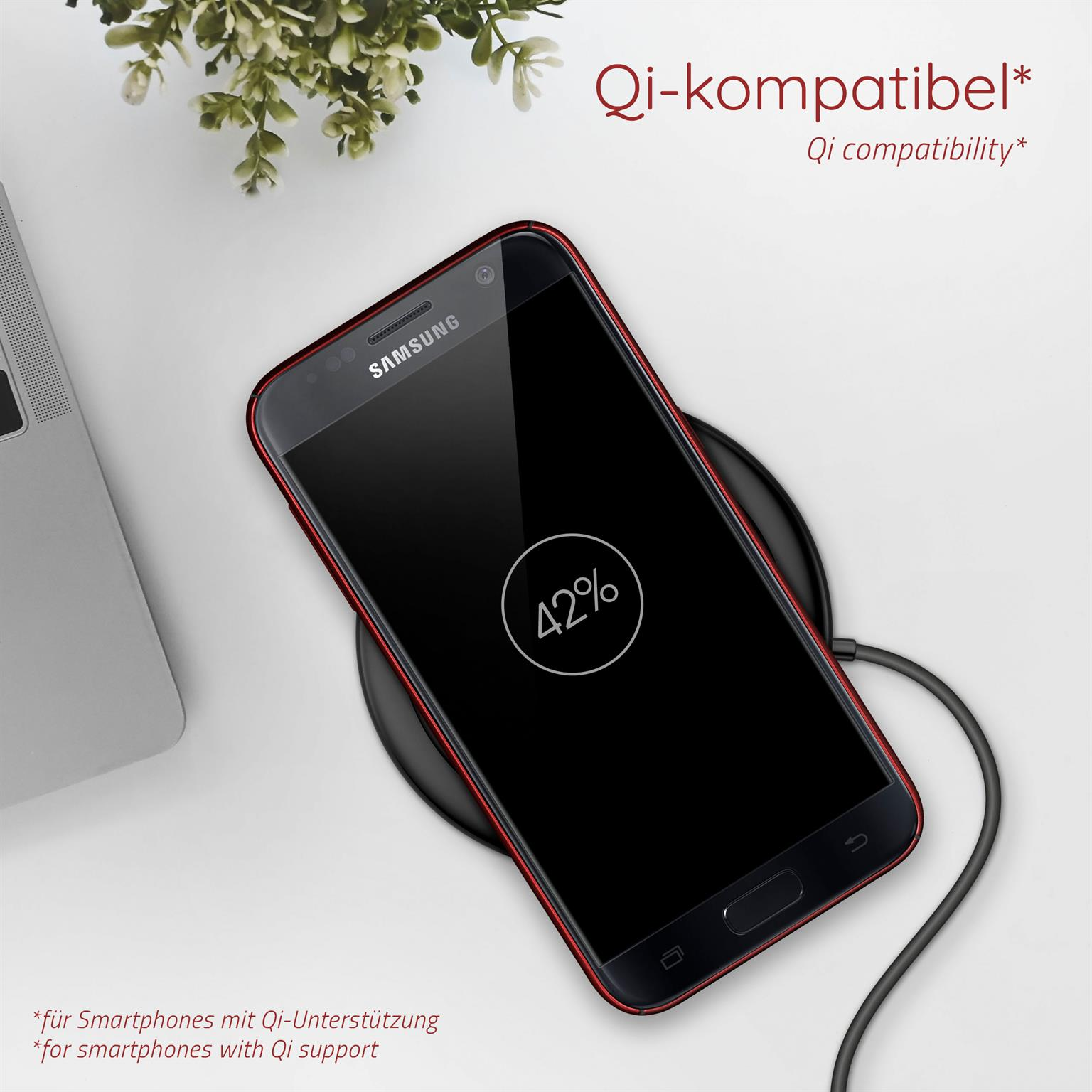 Ein Smartphone wird drahtlos auf einem Pad aufgeladen und zeigt 42 % Akku. Text: Qi-Kompatibilität.