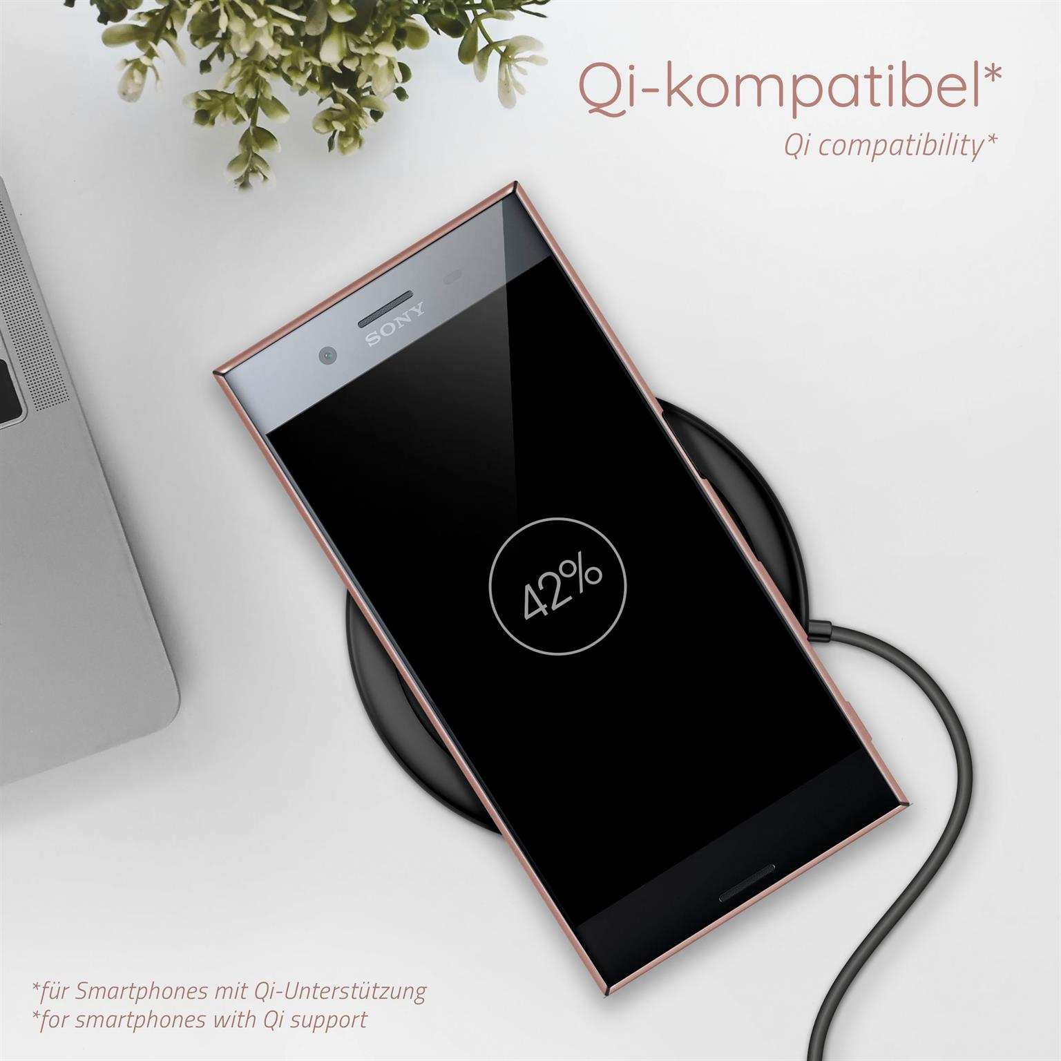 Telefon auf einem kabellosen Ladegerät. Telefon zeigt 42% Ladung. QI-Kompatibilitätstext.