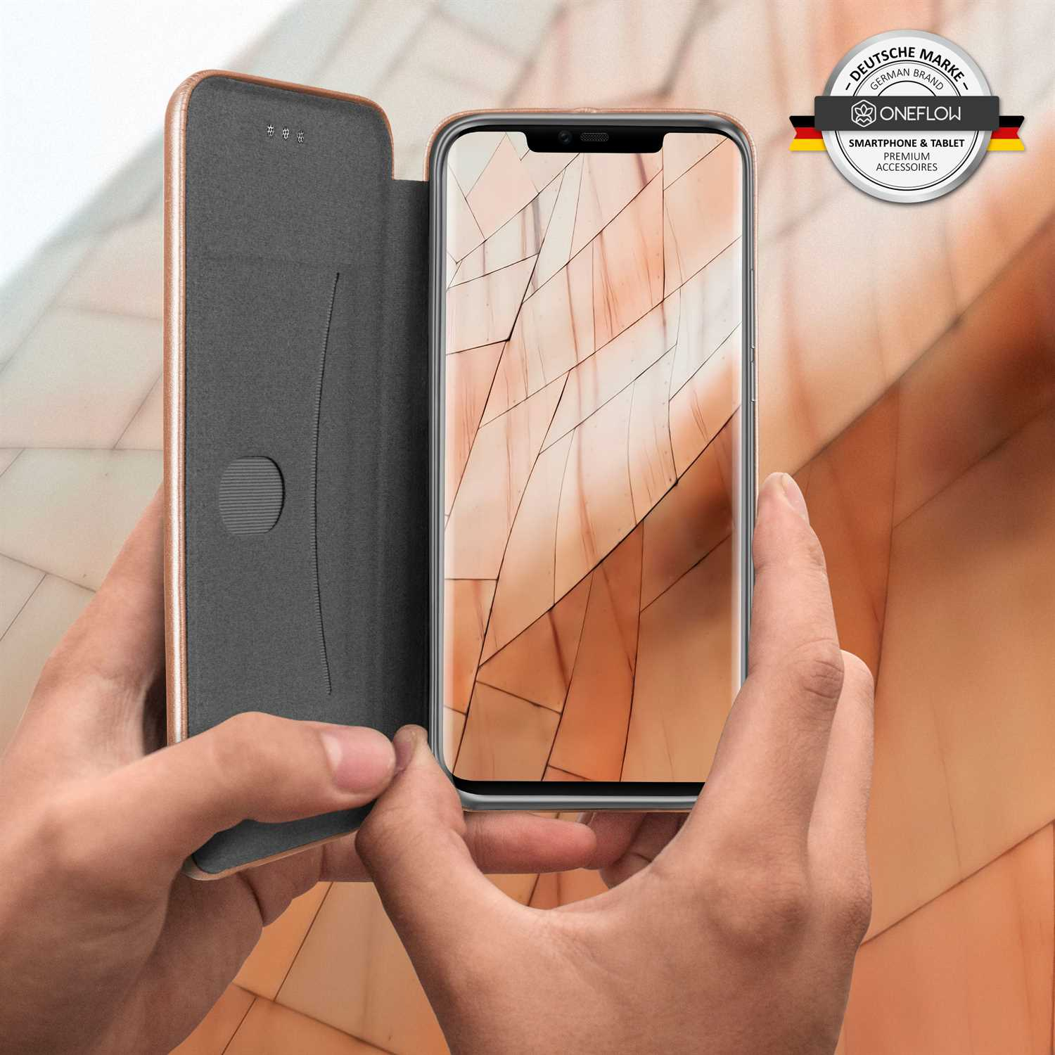 Hände halten eine offene Handyhülle, die ein Telefon zeigt. Hülle und Telefon haben einen strukturierten orangefarbenen Hintergrund.