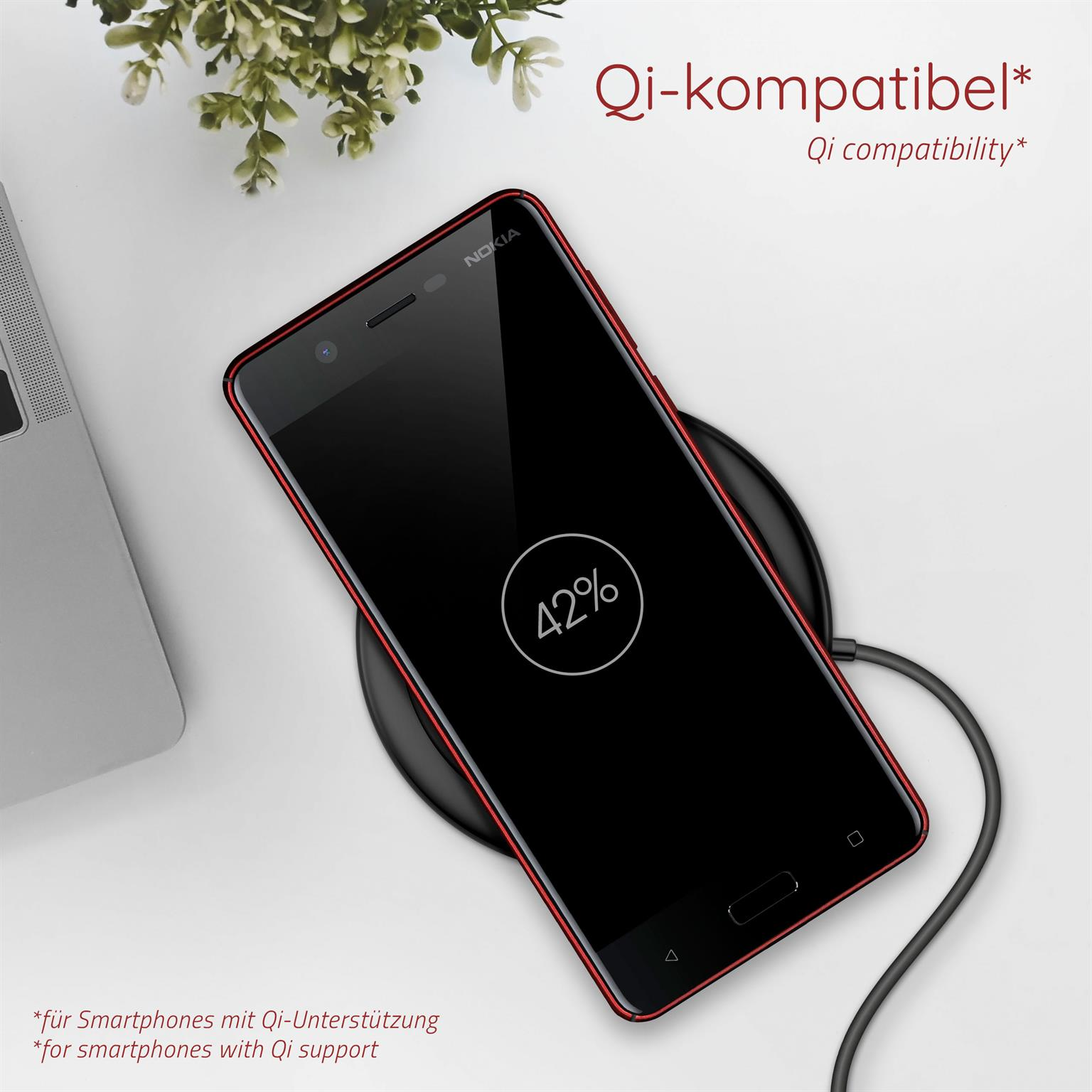 Schwarzes Telefon auf kabellosem Ladegerät, zeigt 42%. Text: Qi-kompatibel, Qi-Kompatibilität.