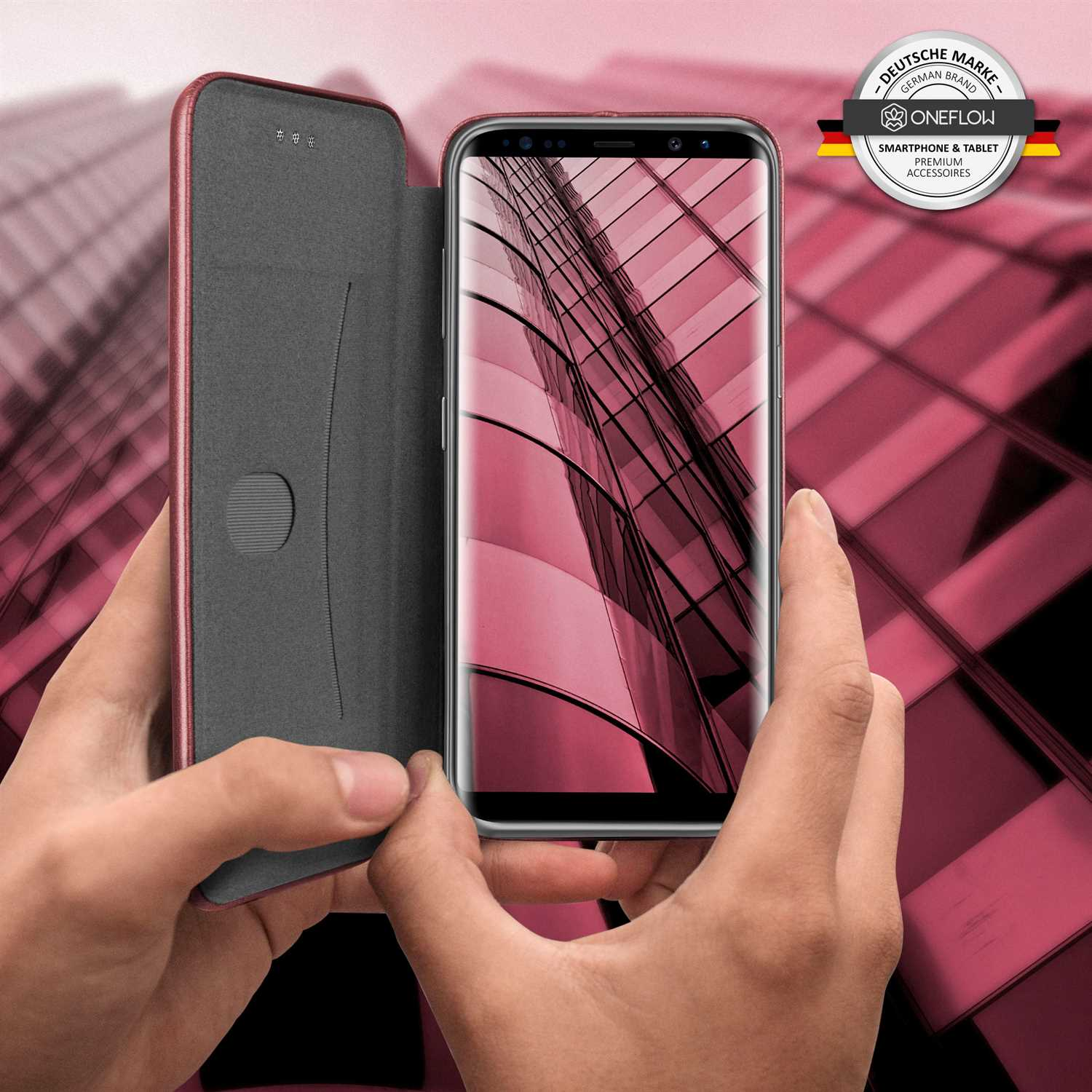 Eine Handyhülle ist geöffnet und gibt ein Telefon frei. Der Hintergrund ist ein rosafarbenes Gebäude.
