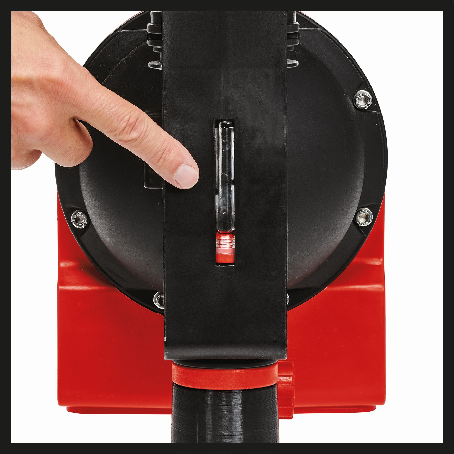 Dłoń wskazująca wskaźnik poziomu na czerwono-czarnej maszynie.