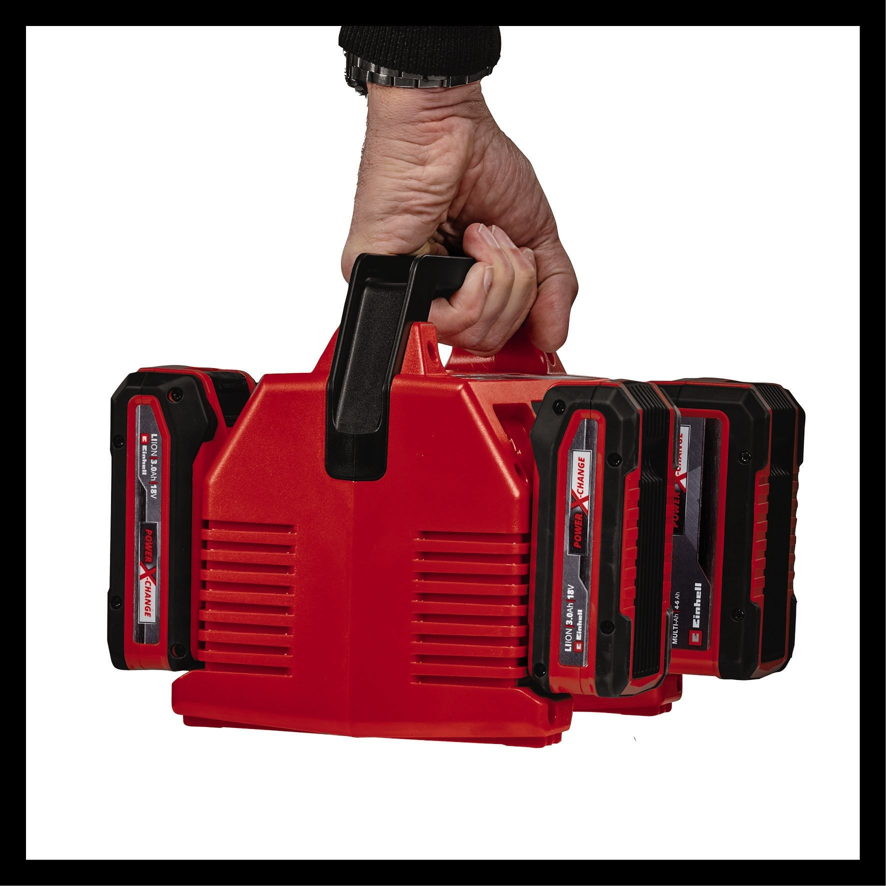 Hand hält roten Werkzeugkoffer mit Batterien. Batterien haben rot und schwarz, Text sichtbar.