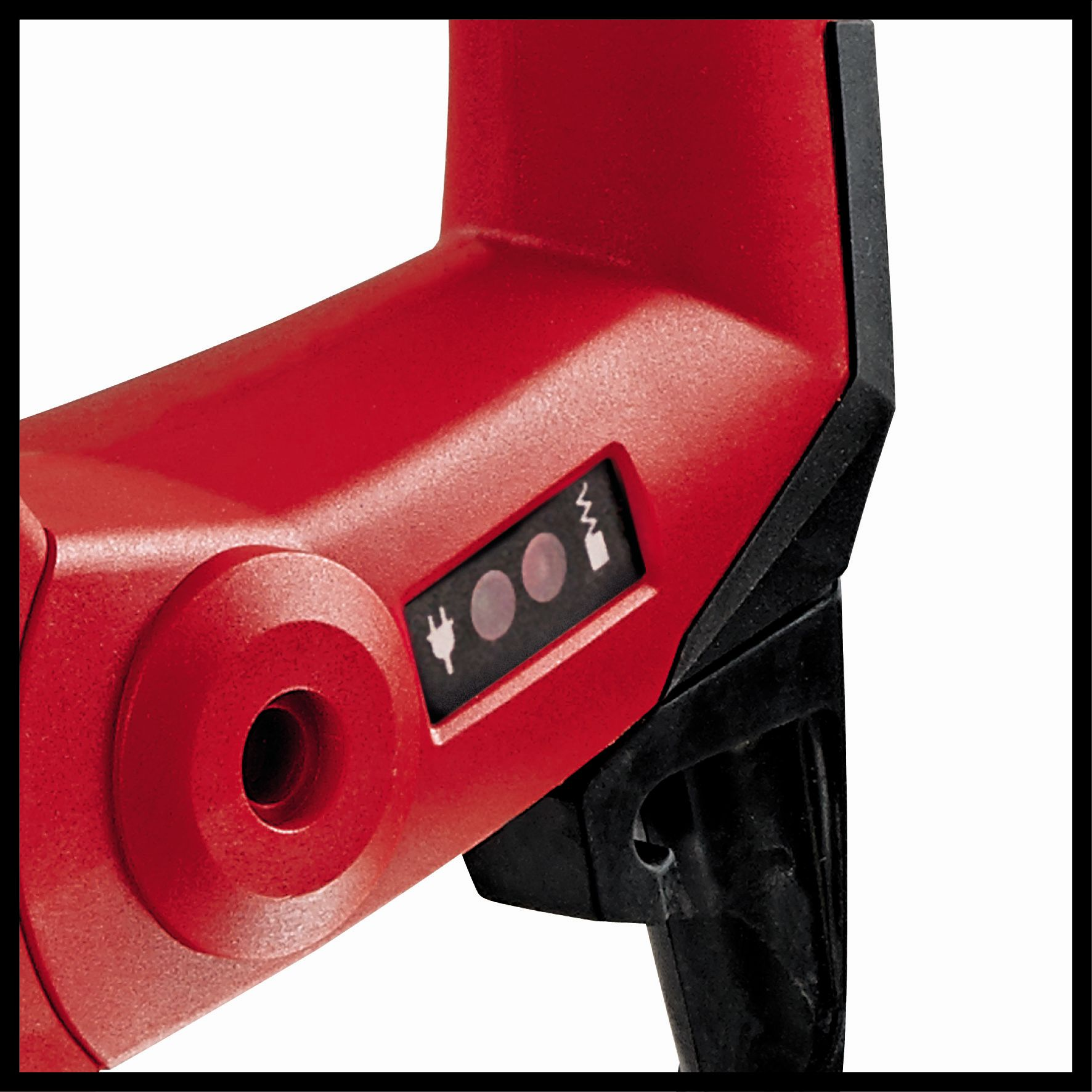 Szczegół czerwonego elektronarzędzia. Pokazuje przycisk z symbolami zasilania i baterii.