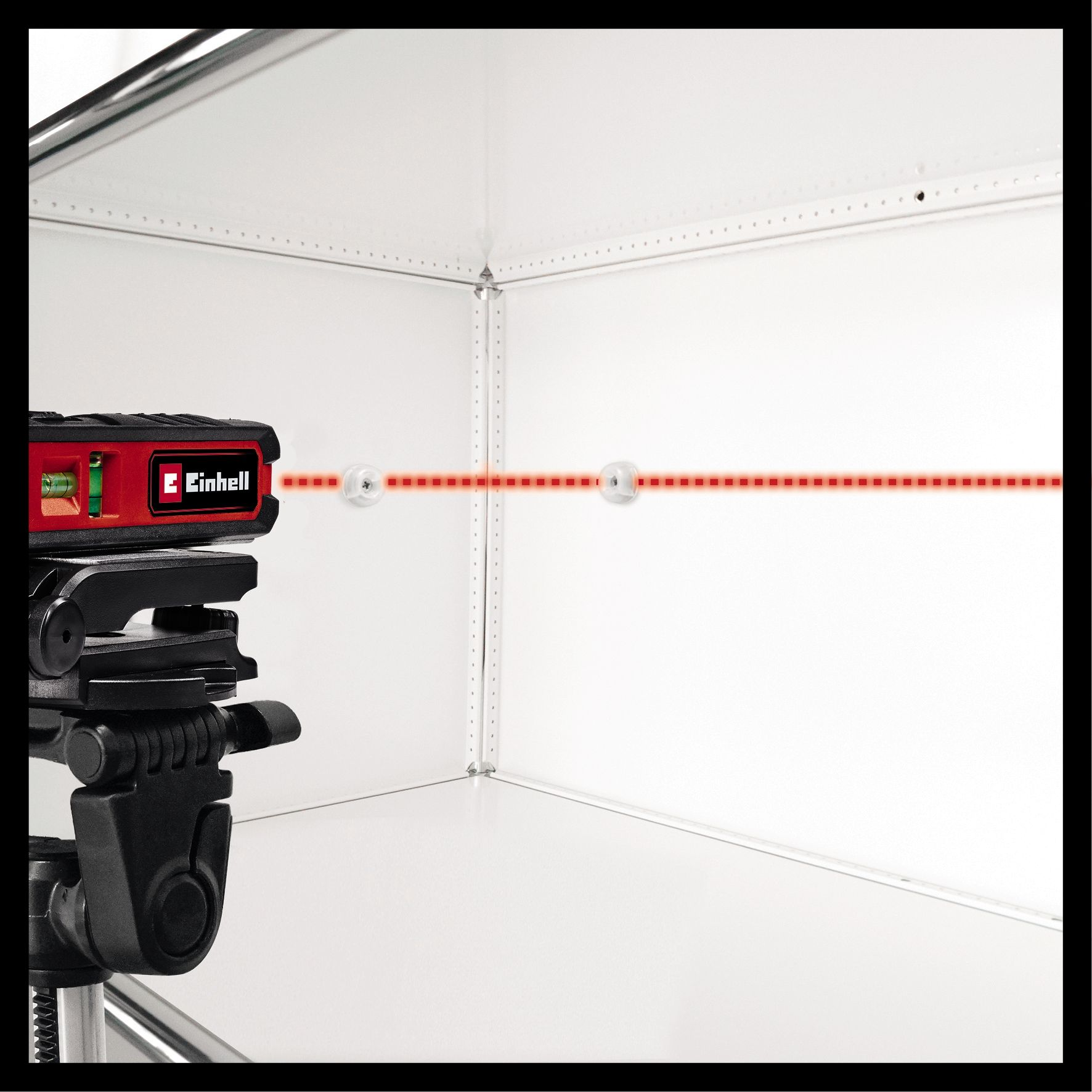 Czerwony niwelator laserowy wyświetla czerwoną linię lasera. Niwelator jest na statywie.