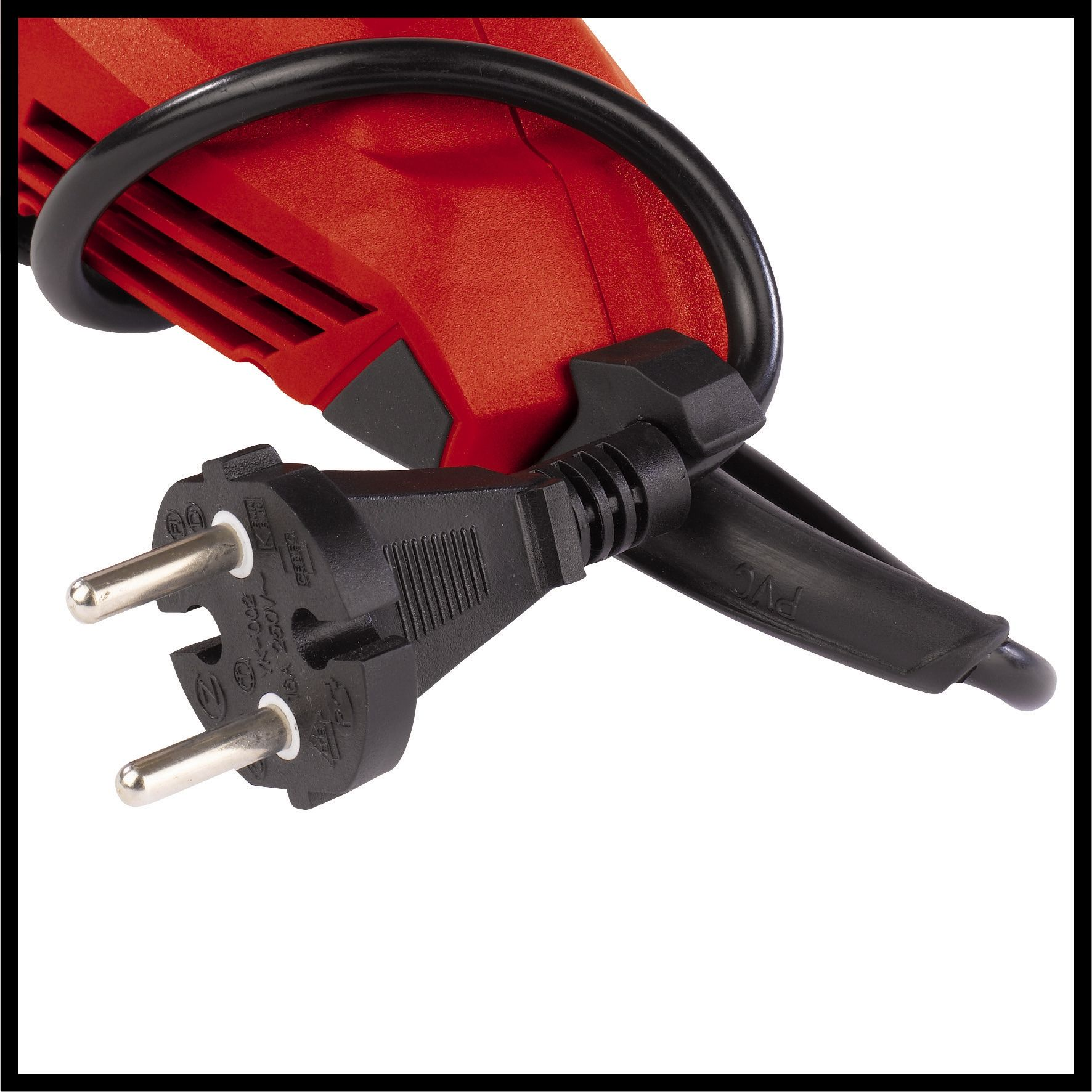 Zbliżenie czarnej wtyczki elektrycznej podłączonej do czerwonego przedmiotu, z napisem „PVC”.