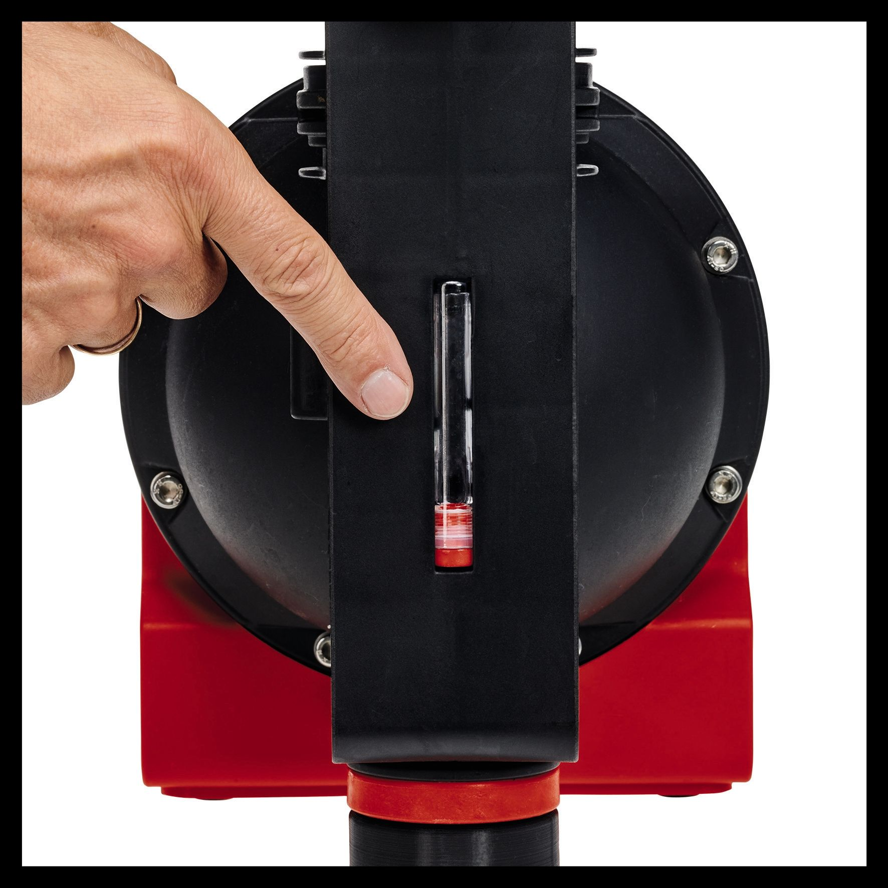 Ręka wskazująca na przezroczysty wskaźnik na czerwono-czarnej maszynie z czerwoną cieczą w środku.