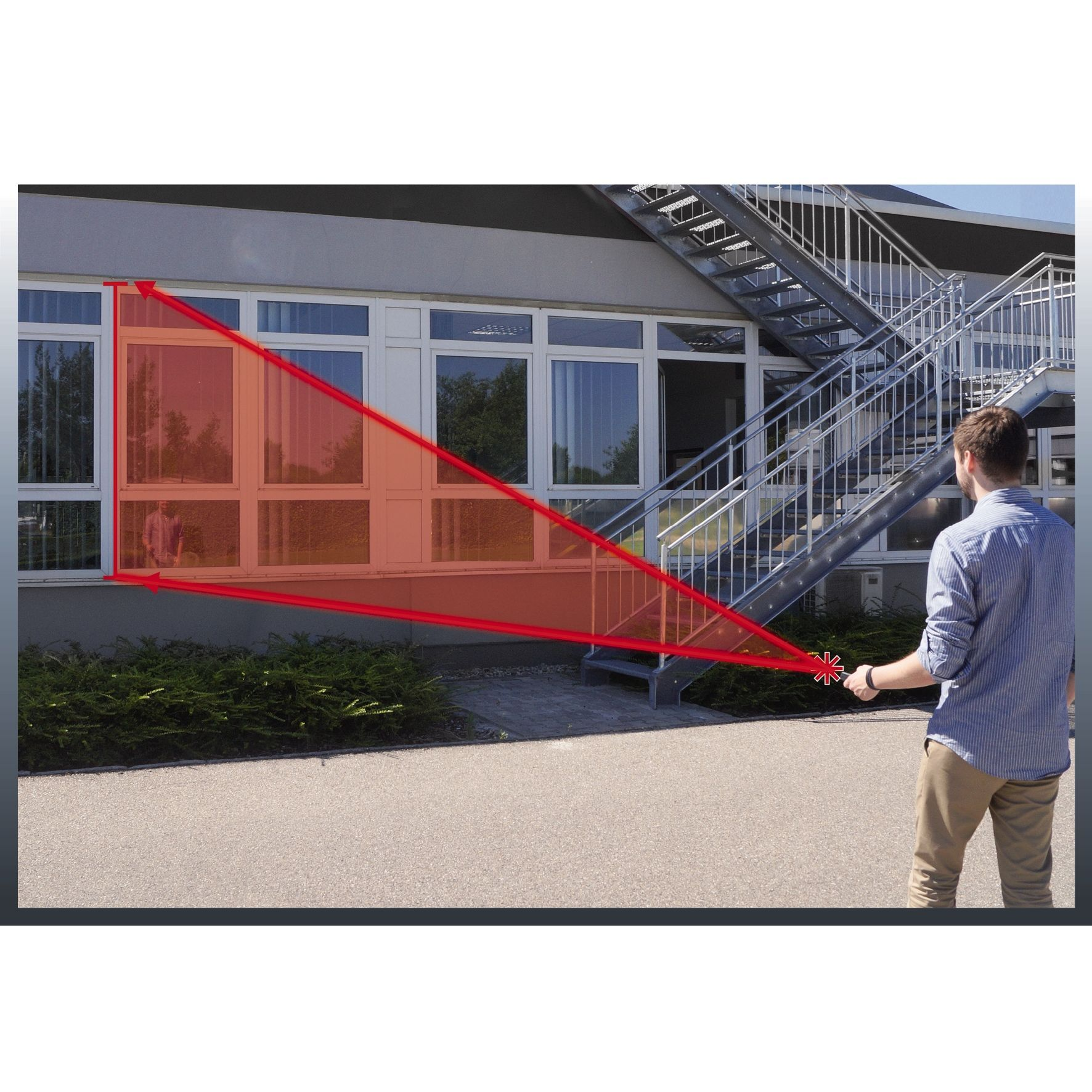Ein Mann zeigt mit einem Laserpointer auf ein Gebäude. Rote Linien zeigen Messungen.