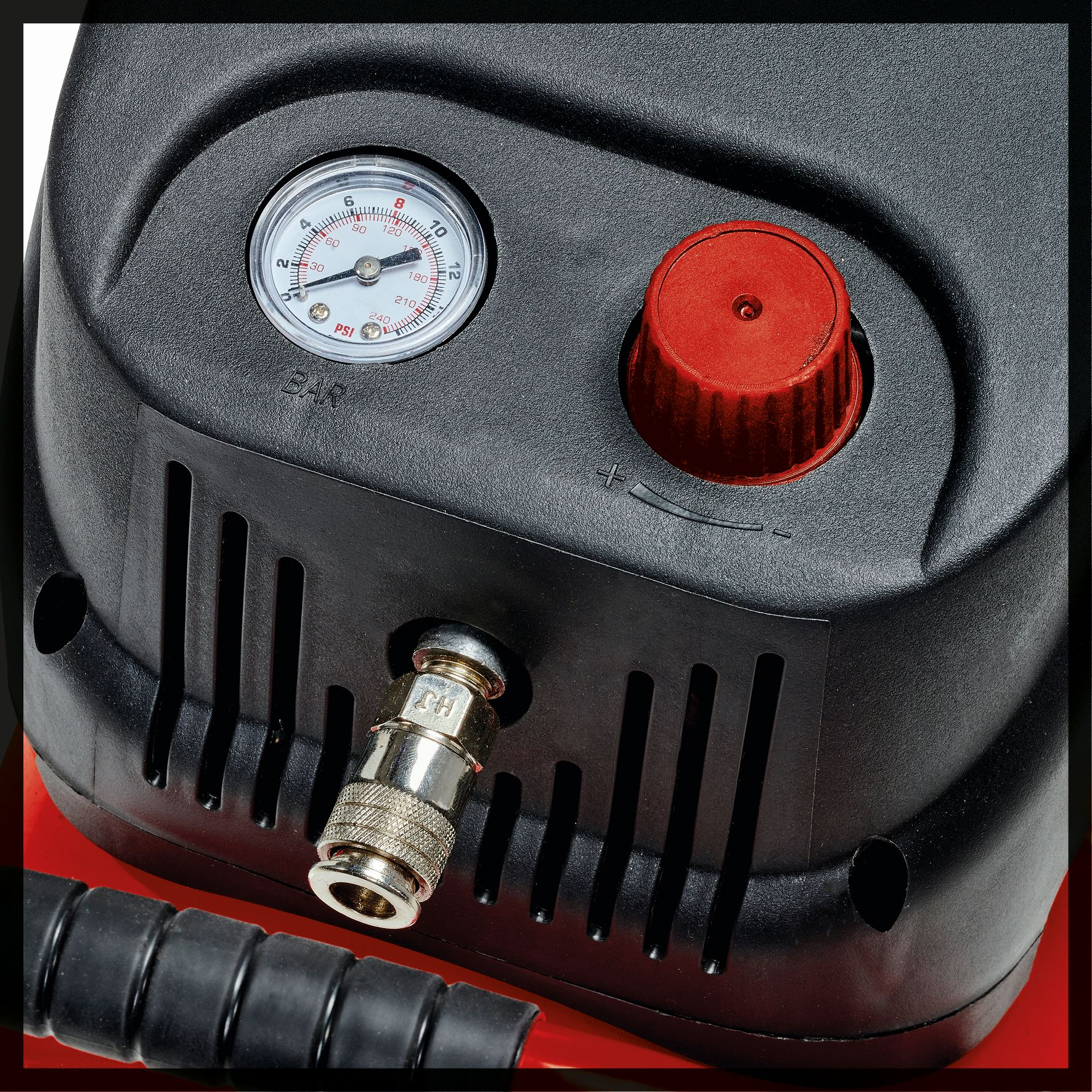 Ein schwarz-roter Luftkompressor mit Manometer und rotem Knopf oben.