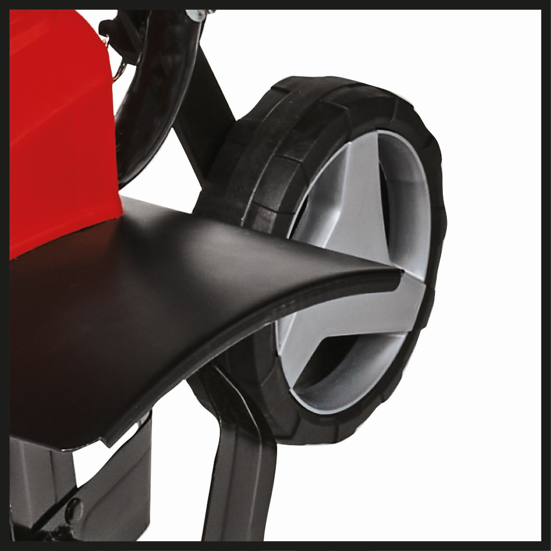 Zbliżenie czerwono-czarnej maszyny, czarne koło ze srebrnym środkiem na białym tle.