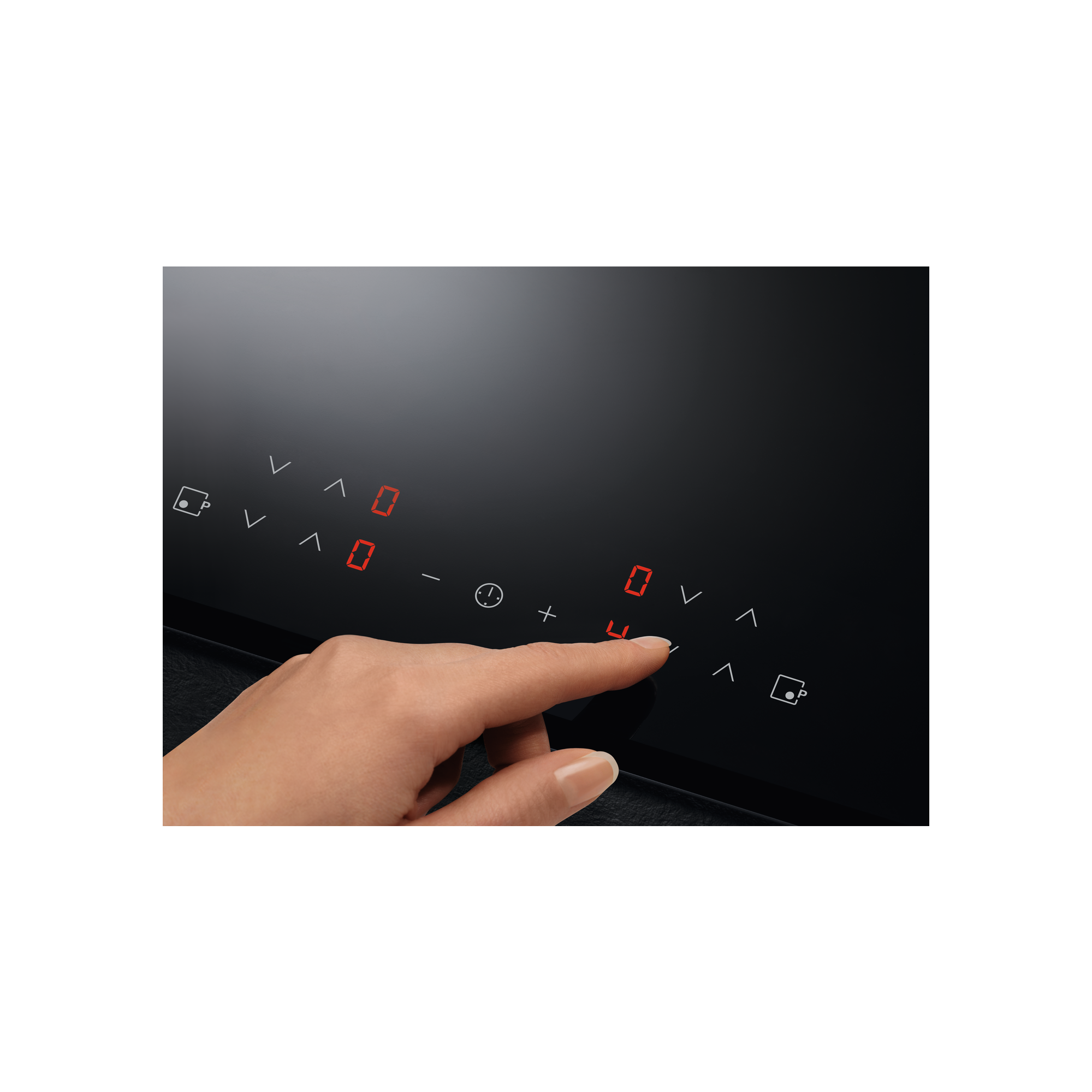 Dłoń dotyka czarnej płyty indukcyjnej, z czerwonymi cyframi.